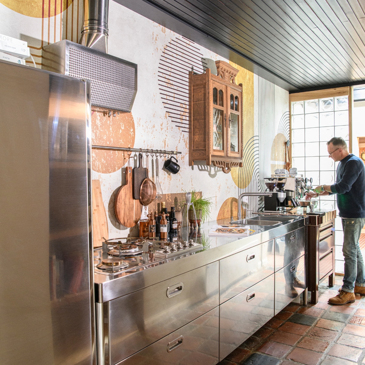 Eiken vitrinekast Marktplaats, servies Teema van Iittala, rvs keuken The Big Easy Kitchen. Naadloos behang Road Trip en structuurbehang Parangon van Casamance via Behangfabriek. Overig onbekend. vtwonen 10-2023 | styling Kim Timmerman | fotografie Louis Lemaire
