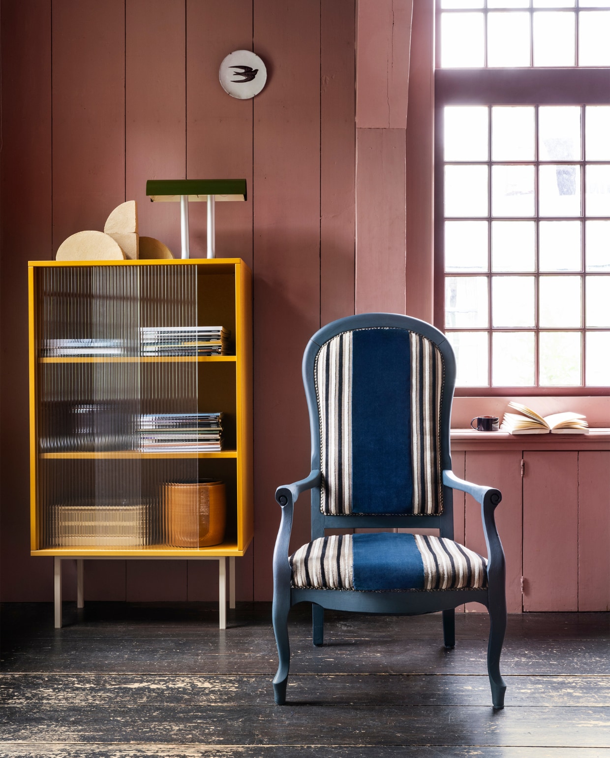 Tweedehands fauteuil € 29,95 (kringloopsaartje.nl). Blauwe verf Dead Flat in Hague Blue van Farrow &amp; Ball, per 0,75 liter € 52,- (deruamsterdam.nl). Velours stof Velluto di Cotone CA1410/053 van Carlucci, 140 cm breed, per meter € 140,- (jab.de). Vitrinekast Color Cabinet, staal en glas, 75x39x130 cm (bxdxh) € 1799,-, aluminium tafellamp Anagram € 295,- (hay.nl). Klei sculpturen Shape van Ferm Living, set van 4 € 175,-, aardewerken gele pot van Serax € 35,- (vtwonen.nl/shop). Bord Zwaluw van Astier de Villatte € 89,- (maisonnl.com). Overig privébezit. vtwonen 10-2023 | styling Marianne Luning | fotografie Stan Koolen | assistentie Rosa van Schie