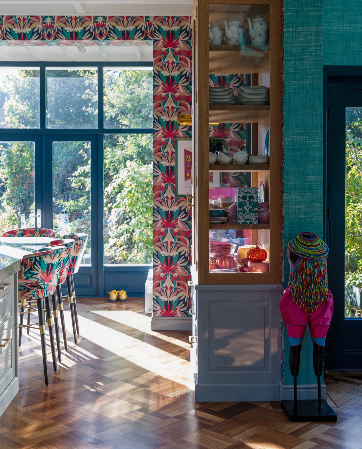 Behang print Harlequin, aquablauw behang Thibaut. Ontwerp barstoelen, keuken en kast Eef Langeler Design, houtverf kozijnen Hague Blue van Farrow &amp; Ball, kunstwerk van Rien Bekkers via Anna Singer Art. Overig onbekend. vtwonen 02-2023 | styling Ilona Jongepier | fotografie Dana van Leeuwen