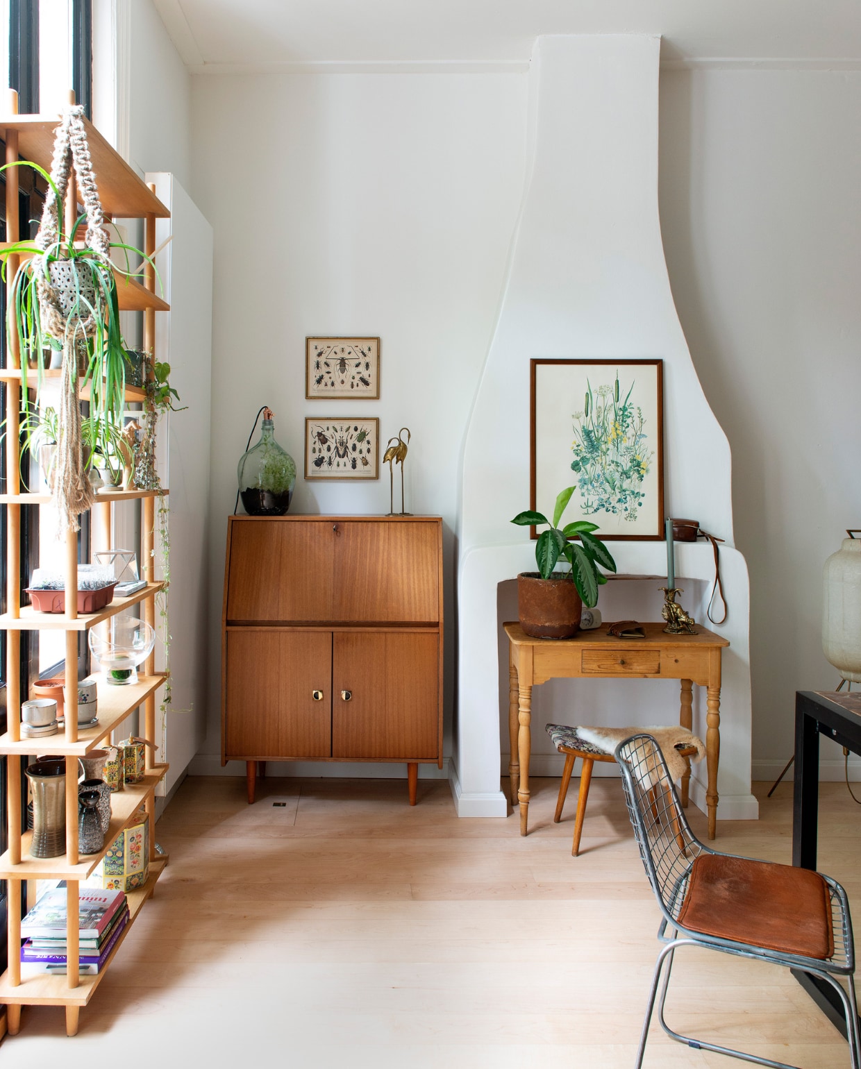 Muurverf verkeerswit Ral 9016. Stokkenkast, secretaire, voetenbank, lijsten met prints, vazen en object flamingo’s vintage vondsten, soortgelijke kasten @trashuresnl. Bureau erfstuk van Toms oma. Tafel Giga Meubel, stoel Dutchbone. Macramé plantenhanger, pot met plant en kweekbak Tuinland. Vazen kringloop. Bloempotten kringloop, minituin erin zelfgemaakt. Vintage driepootlamp StrangeAvenue. vtwonen 01-2021 | styling Jeske Weel | fotografie Caroline Coehorst