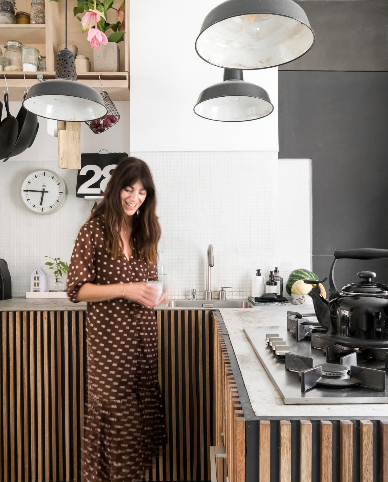 Koelkast Smeg, vintage klok van Pragotron gekocht bij Blom &amp; Blom. De keuken die William maakte is een hit op Pinterest. Het werkblad is van beton, de kastdeuren van zwarte mdf met slaglatten in meranti-hout. Lampen van een brocantemarkt in Frankrijk. vtwonen 2-2020 | styling &amp; fotografie Jonah Samyn