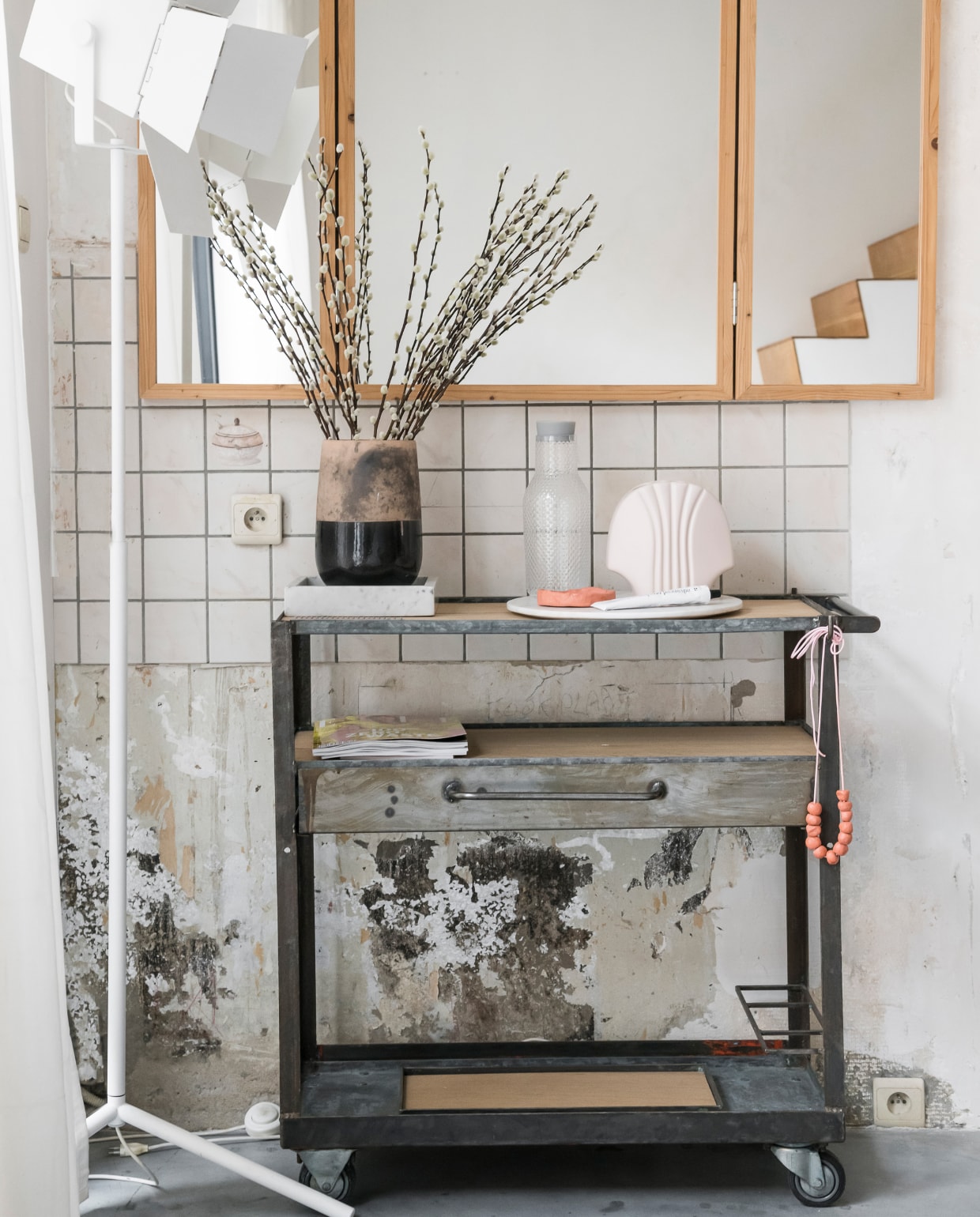 Liene en William vinden het niet nodig de sporen van de oude keuken uit te wissen. Dat geeft karakter aan hun huis. Spiegel van Piet Hein Eek, rolwagentje van Williams eigen merk Wøti. Lamp Design District, pot Mirte in Leuven. vtwonen 2-2020 | styling &amp; fotografie Jonah Samyn