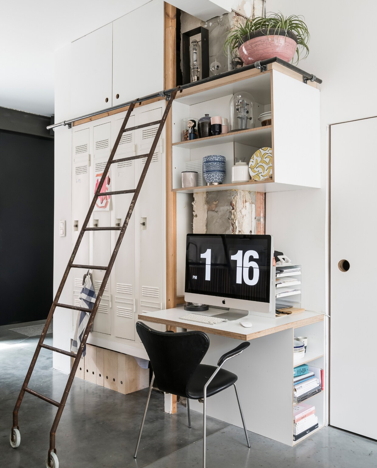 De ladder en ingebouwde lockerkast komen uit de oude verlaten brouwerij van Stella Artois. Op deze foto is duidelijk te zien dat elke vierkante centimeter wordt benut en dat er enorm veel bergruimte is. Zwarte stoel van Arne Jacobsen. vtwonen 2-2020 | styling &amp; fotografie Jonah Samyn