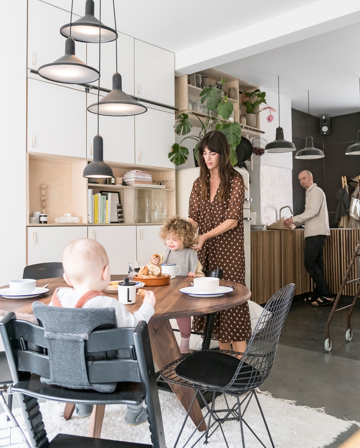 De tafel in Amerikaanse notelaar, keuken en inbouwkast zijn door William gemaakt. Wire Chair van Eames voor Vitra, Tripp Trapp stoel van Stokke. Lampen boven tafel Torch Light van Established &amp; Sons. Vloerkleed Jinzu. vtwonen 2-2020 | styling &amp; fotografie Jonah Samyn