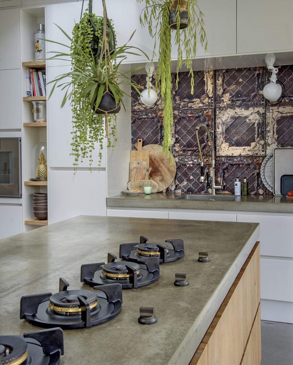 Kookpitten Pitt. De nis is bekleed met behang Brooklyn Tins van NLXL. Lampen van Jieldé, ronde plank HK Living. Olijfhouten planken mee- genomen van Sicilië, dienbladen gekocht in New York en Parijs. vtwonen 01-2019 | fotograaf Ton Bouwer | styling Wendy Romeijn en Monique van der Pauw