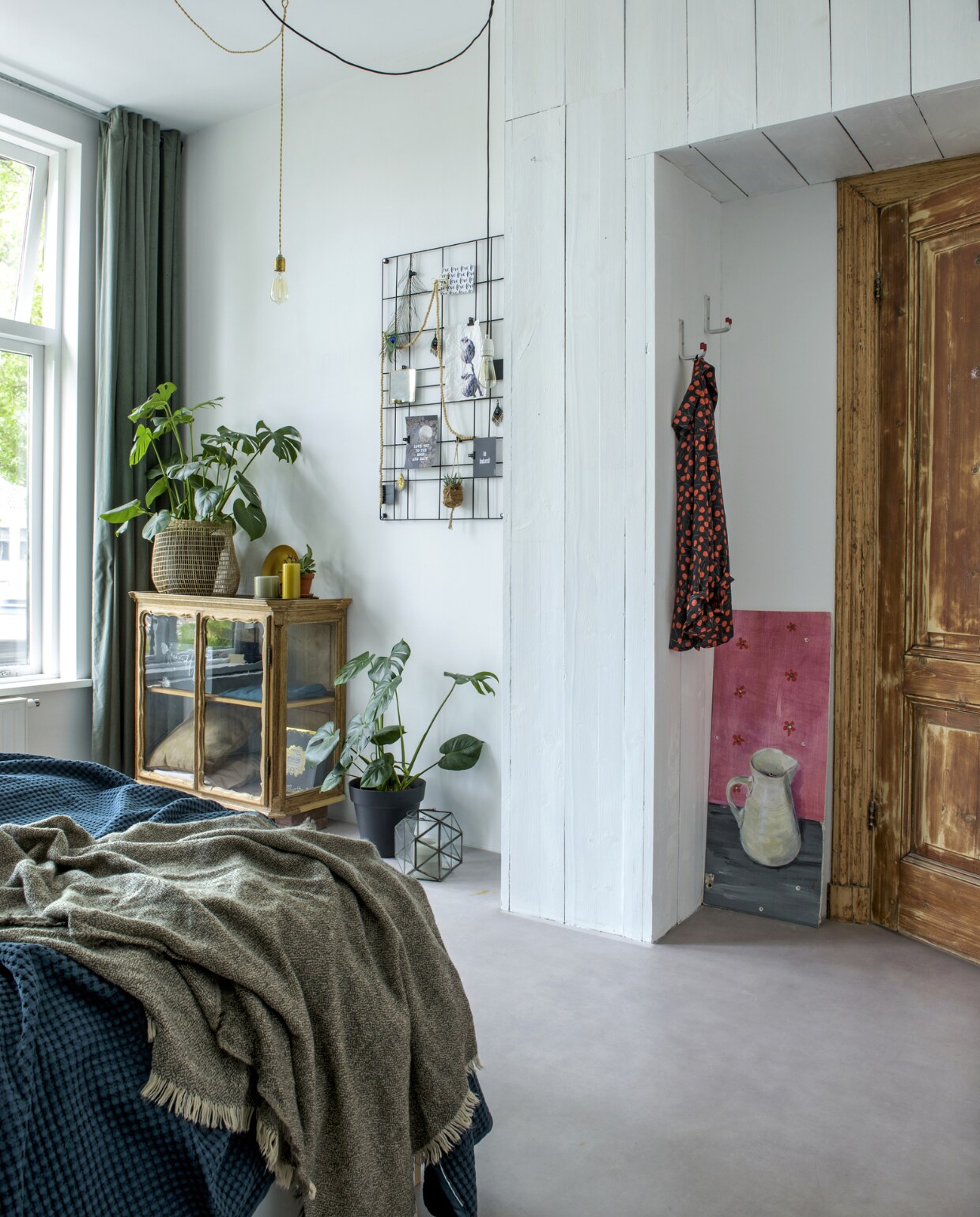 De underlayment kastenwand loopt om de hoek door en biedt ook boven de slaapkamerdeur nog bergruimte. De nissen maken de ruimte meteen wat speelser en intiemer. Vintage hangkastje gekocht van een vriend, wandrek en mand van vtwonen.nl. Gouden bordje hert van &amp;klevering. Kaarten, kaarsen, planten, windlicht van Groene Vingers Delft. Snoer, fittingen en haken van Karwei. Gordijnen Ikea.Sissy-Boy. Herkomst plaid onbekend. vtwonen 01-2019 | fotograaf Ton Bouwer | styling Wendy Romeijn en Monique van der Pauw