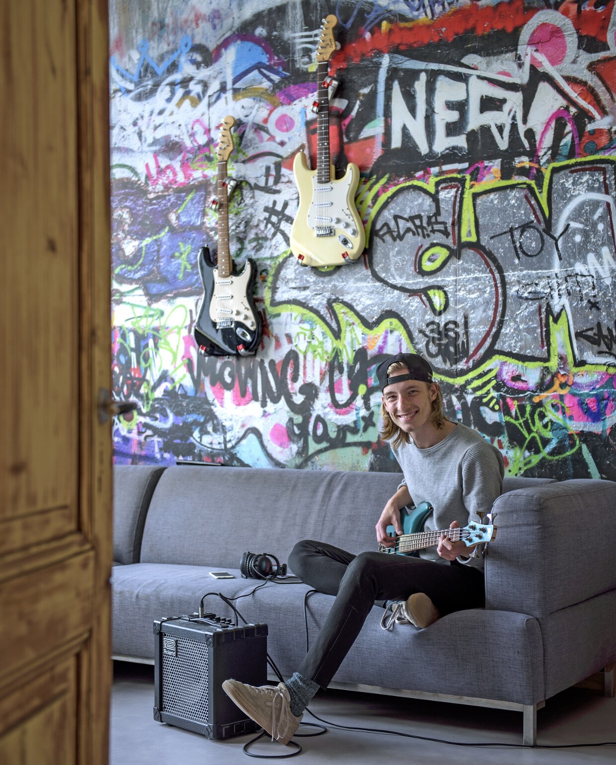 de kamer van gitaarspeler Nemo kreeg een graffiti-print, met behang gevonden op internet, herkomst onbekend. in op haar kamer, met een rotan bankje gekocht bij groot- handel Tica. Eames look-a-likes van Domini Design, een rotan tafeltje van Groene Vingers Delft, een wit tafeltje van Kwantum en een zelfgemaakt boomstamtafeltje. Kussen met hert van Groene Vingers Delft, lamp van Ikea, kaartenrek Hema, gouden hangrekje van Sissy-Boy, houten snijplank uit kerstpakket. vtwonen 01-2019 | fotograaf Ton Bouwer | styling Wendy Romeijn en Monique van der Pauw