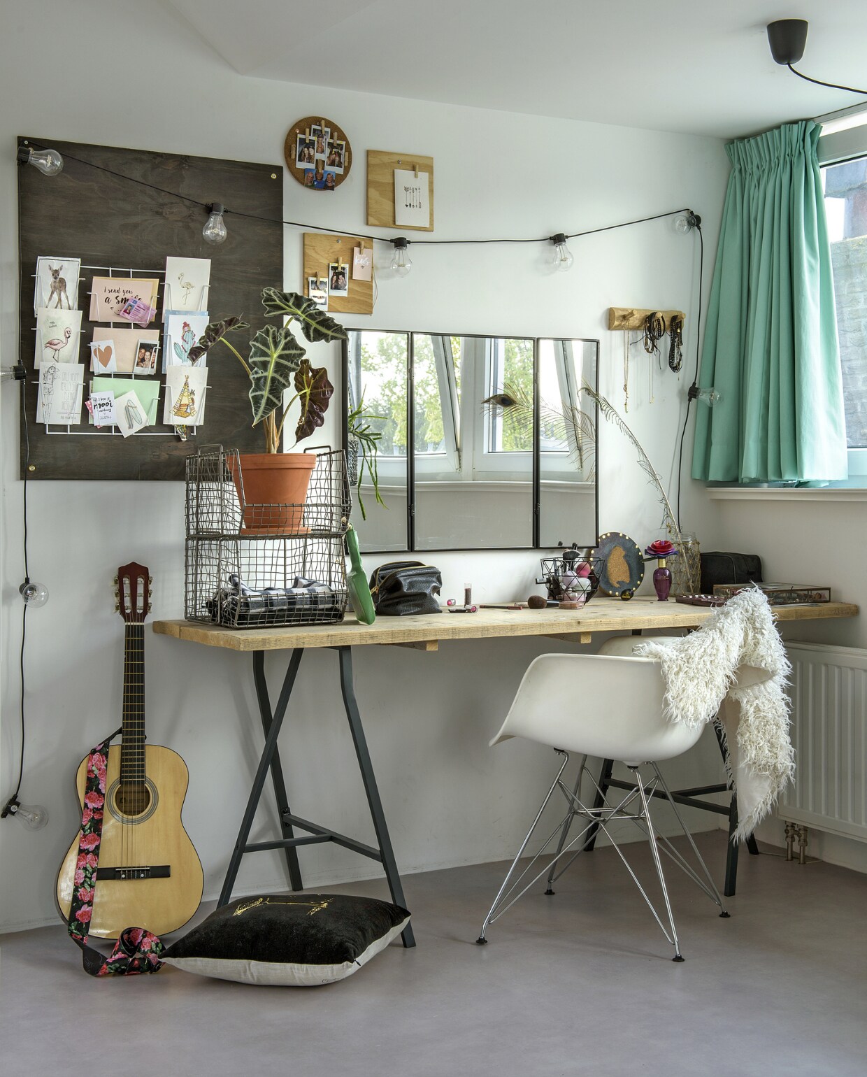 Een blad van steigerhouten planken op schragen doet dienst als make-uptafel voor Lola. Schragen en spiegel Ikea. Het kaartenrek van Hema is gemonteerd op een grijs geschilderd underlayment, zo springen favoriete kaarten nog beter in het oog. Lampsnoer en draadmand Groene Vingers Delft, kussen Zusss, stoel Domini Design. vtwonen 01-2019 | fotograaf Ton Bouwer | styling Wendy Romeijn en Monique van der Pauw