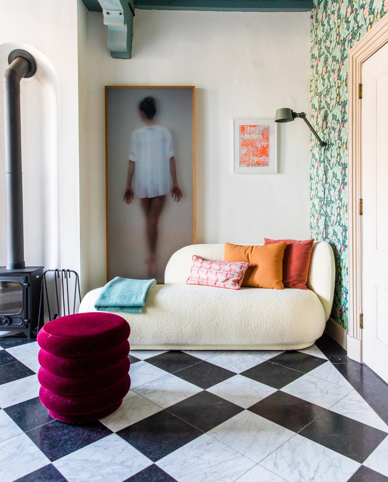 Houtkachel Dover, kunstwerk Casper Faassen, klein kunstwerk reclameposter uit Londen. Bank en poef Ferm Living. Behang Morris & Co., wandlamp Tonone. Kussens Hay en zelfgemaakt. Blauwe plaid Hay, marmeren vloer origineel. Verf plafond Oval Room Blue van Farrow & Ball. vtwonen 10-2023 | productie CocoFeatures | fotografie Laura Emma van Geest