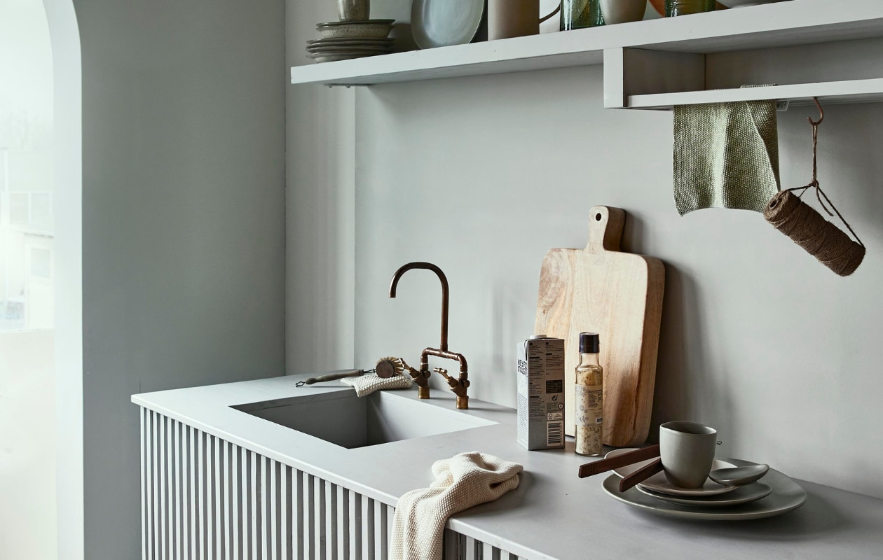 Muurverf Glass (wand) en Wave (boogvorm en keuken) Karwei, keuken en wandplank op maat gemaakt door Combitex, stapel borden en bekers op plank, theedoek en gebreide vaatdoek iblaursen.com, rechtopstaande keramieken borden, broodplank, glazen kan, keramieken kan, beker naast schaal nordal.eu, houten bord restored.nl. Overig privébezit. vtwonen 04-2020 | styling Cleo Scheulderman | fotografie Jeroen van der Spek