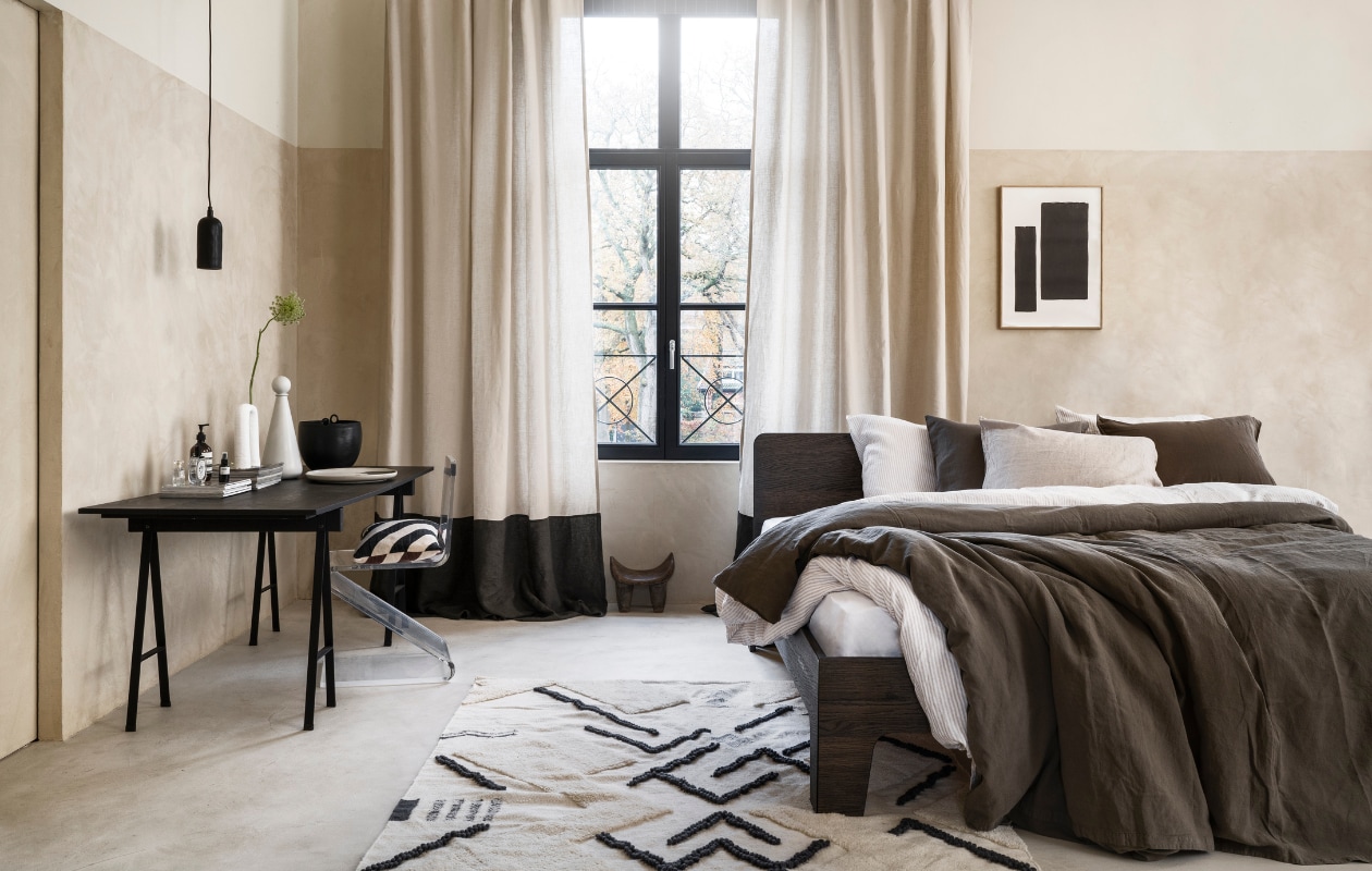 Stucco-look muurverf Mykonos, 2,5 liter € 110,- (wearewowmakers.com). Gordijn gemaakt van linnen Cloud Rider van Chivasso, per meter € 114,50 (jab.de). Bedombouw Pure, eiken fineer in Charcoal olie, 180x200 cm (bxd) € 3400,- (loof.nl). Duurzaam gewassen linnen dekbed-overtrekset met smalle strepen, 240x220 cm € 329,- (yumeko.nl). Bruine dekbedovertrekset, duurzaam linnen en katoen, 240x220 cm € 179,95 (suite702.com). Vloerkleed, 260x160 cm € 399,- (malagoon.com). Tafel van Serax, 150x75x73cm (lxbxh) € 824,-, vaas met bolvormig deksel van Ferm Living € 85,-, schaal Omhu van Ferm Living € 105,- (flinders.nl). Vintage transparante zigzagstoel € 350,- (neeflouis.nl). Hanglamp € 79,95, pot met oor € 62,95 (urbannatureculture.com). Vaas met twee poten van vtwonen € 49,95, gestreept kussen van Oyoy € 54,99 (vtwonen.nl). Poster met lijst vanaf € 95,- (loods5.nl). Afrikaans krukje privébezit. vtwonen 03-2023 | styling Marianne Luning | fotografie Stan Koolen