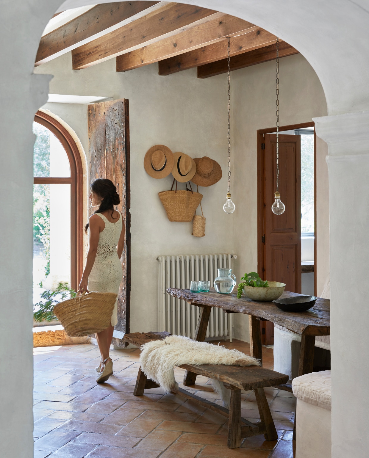 Hoeden, manden en glaswerk lokaal gekocht. Tafel lokaal gemaakt van oude eiken wijnvaten. Hanglampen zelfgemaakt. Keramiek uit eigen atelier. Schapenvacht via hun eigen bedrijf Terra Coll Home afkomstig van een Ierse boerderij. vtwonen special binnenkijken 06-2023 | productie Bureaux/Living Inside | fotografie Greg Cox