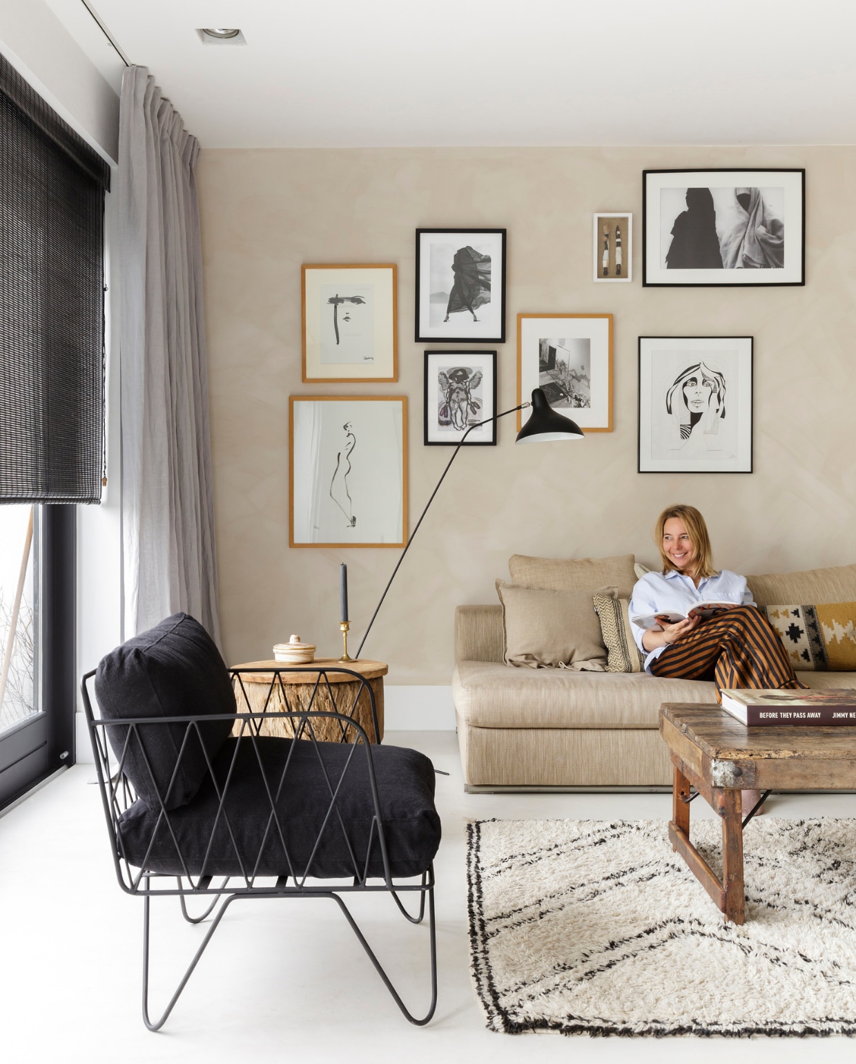 Op de muur in de woonkamer zit kleur Ibiza van het merk Bauwerk via wearewowmakers.com, linnen gordijnen van Ikea, ‘die laat ik lekker kreuken’. Vloerkleed via AnoukB, Marokkaanse stoel van Household Hardware. Zandkleurige bank Ground Piece van Flexform, vloerlamp Mantis van DCW. Vintage salontafel v gevonden in Londen met een foto van de Deense fotograaf Rie Rasmussen. Twee handgemaakte poppetjes uit Kaapstad, portret van twee Berber vrouwen uit Marrakech van lokale fotograaf, illustratie rechtsonder van Sanne Nadine Hes. Rolgordijn via Cabana Interior. vtwonen 11-2018 | fotografie Margriet Hoekstra | styling Barbara Natzijl