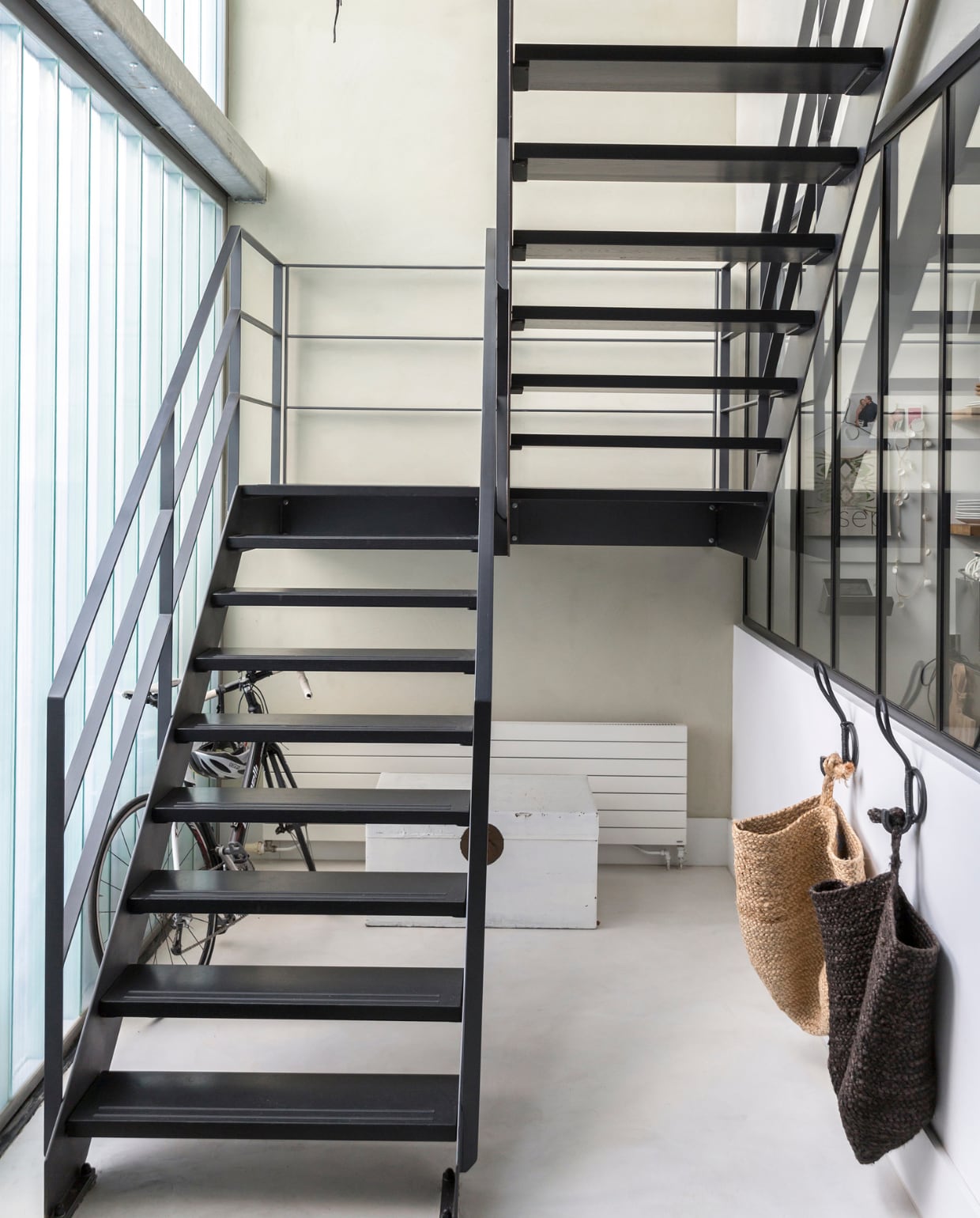 ‘De stalen trap is een idee van de architect om het modern, industrieel en tijdloos te maken en niet te rommelig.’ Hangzakken van Aai made with Love. Hanglamp van Ay Illuminate. vtwonen 11-2018 | fotografie Margriet Hoekstra | styling Barbara Natzijl