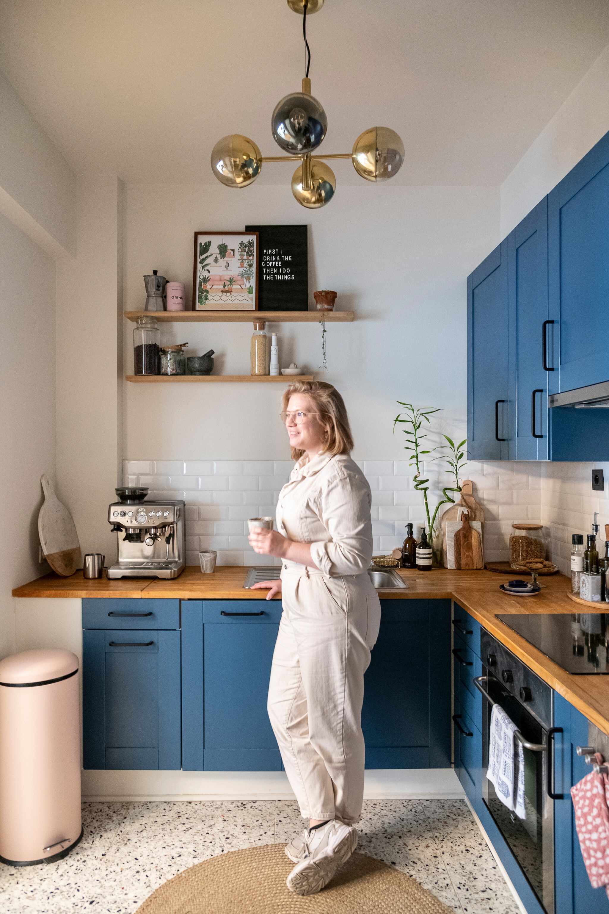 Keukenkasten en werkblad Ikea, kasten geschilderd met Ck Dc 9-c Boss Paints via Colora. Terrazzo vloertegels Impermo, verlichting en ronde mat Westwing, roze vuilnisbak Made, koffiemachine Sage, snijplanken H&amp;M Home, wandplank zelfgemaakt, lijst allthewaystosay.com, letterbord Hema, potten Ikea. Vijzel H&amp;M home, handzeep Aeosop. vtwonen 09-2022 | fotografie Jonah Samyn