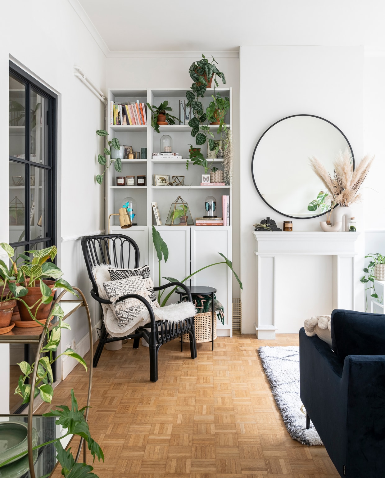 &gt; Schoorsteenmantel Maisons du Monde, kaars P.F. Candle Co, vaas H&amp;M Home, marmeren boekensteunen Wunderkammer, mosbol in water Juttu. Ronde spiegel Sissy-Boy. Zwarte rotan fauteuil, schapen- vacht en kast Billy Ikea. Bijzettafel Sofacompany. In de kast: stolpen met vlinders Piet Moodshop, vintage stolpen Wunderkammer, kaarsen Soy Hive Candles. Kussens in de fauteuil La Redoute en reissouvenir uit Bali. Overig onbekend. vtwonen 09-2022 | fotografie Jonah Samyn