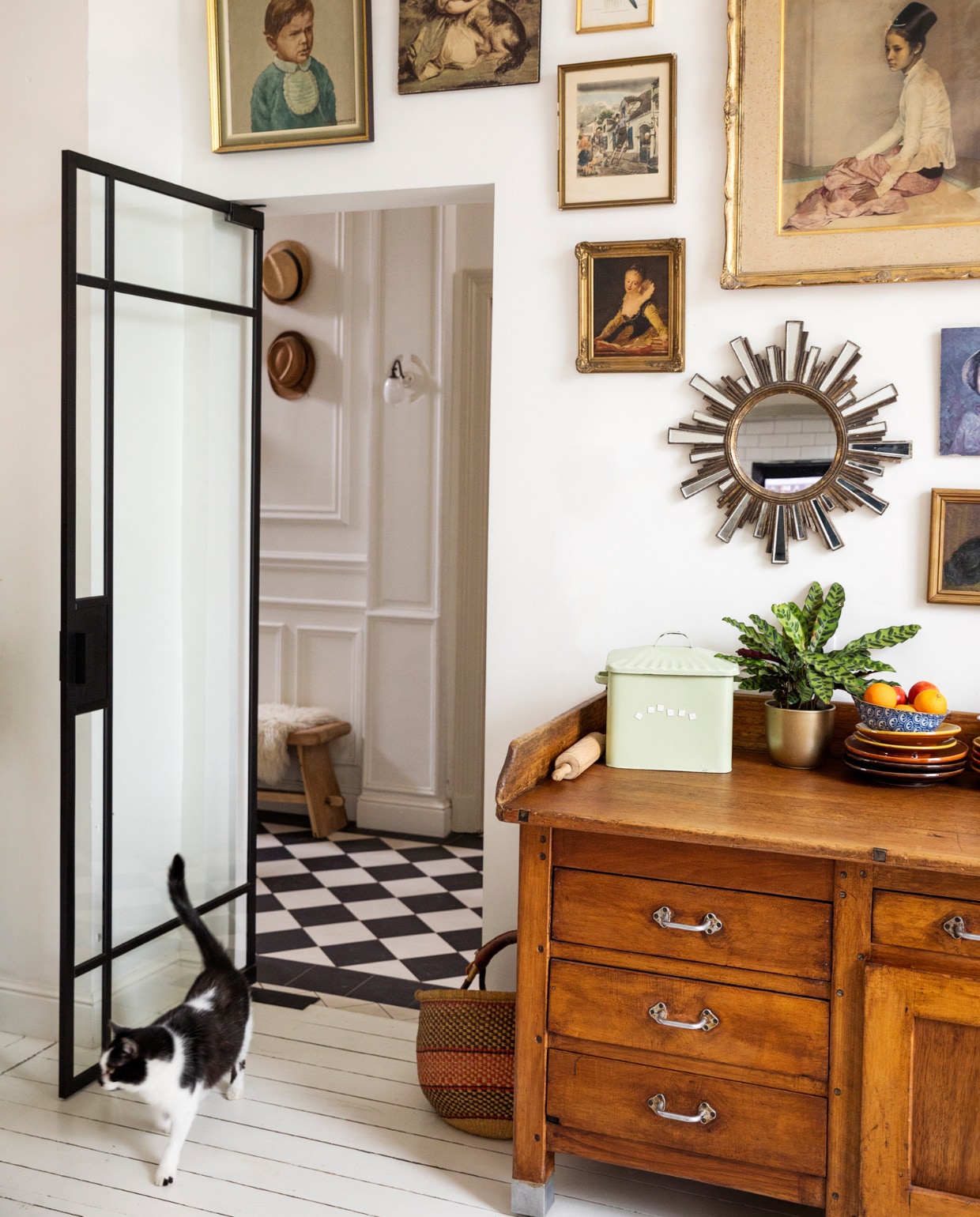Verf muur en vloer Ral 9010, vloertegels hal Villeroy & Boch. Bank Polspotten, schapenvacht Ikea, wandlamp ’t Glashuys. Lijsten kringloopwinkels en rommelmarkten, spiegel brocante, keukenblok/oud bakkersmeubel Woontheater. Mand markt, blik souvenir, plant en pot Van Uytsel, servies Marokkaanse winkel. Overig onbekend. vtwonen 10-2023 | styling Ilona Jongepier | fotografie Dana van Leeuwen