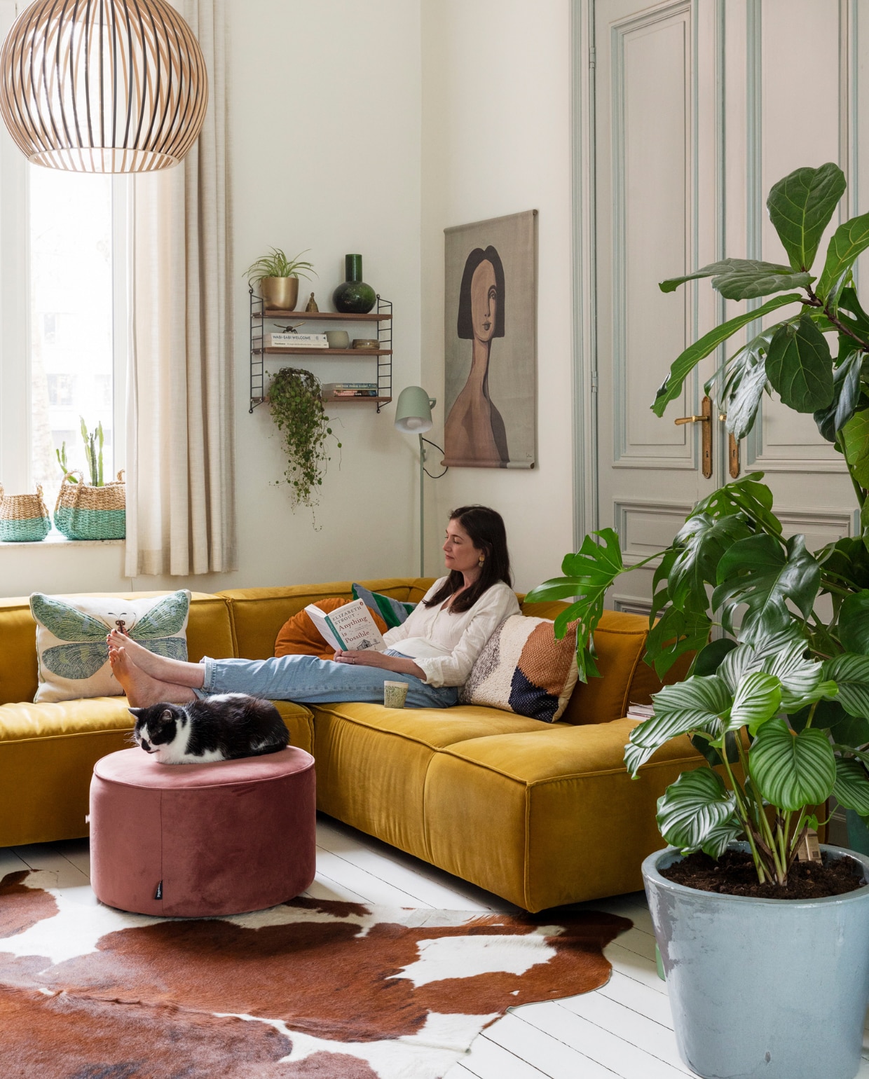 Verf muur en vloer Ral 9010, verf deuren Light Blue van Farrow & Ball. Gordijnen op maat laten maken, hanglamp Octo van Secto. Manden Hema en Maisons du Monde. Wandrek String, potten en planten Van Uytsel. Vaas, schilderij en kussen met bruine vlakken HKliving. Vloerlamp Lau van Zuiver, bank Dunbar van Fést. Kussens vlinder en streep Sissy-Boy, rond kussen Ikea, poef Sara van Woood, vloerkleed koevel van de markt. vtwonen 10-2023 | styling Ilona Jongepier | fotografie Dana van Leeuwen