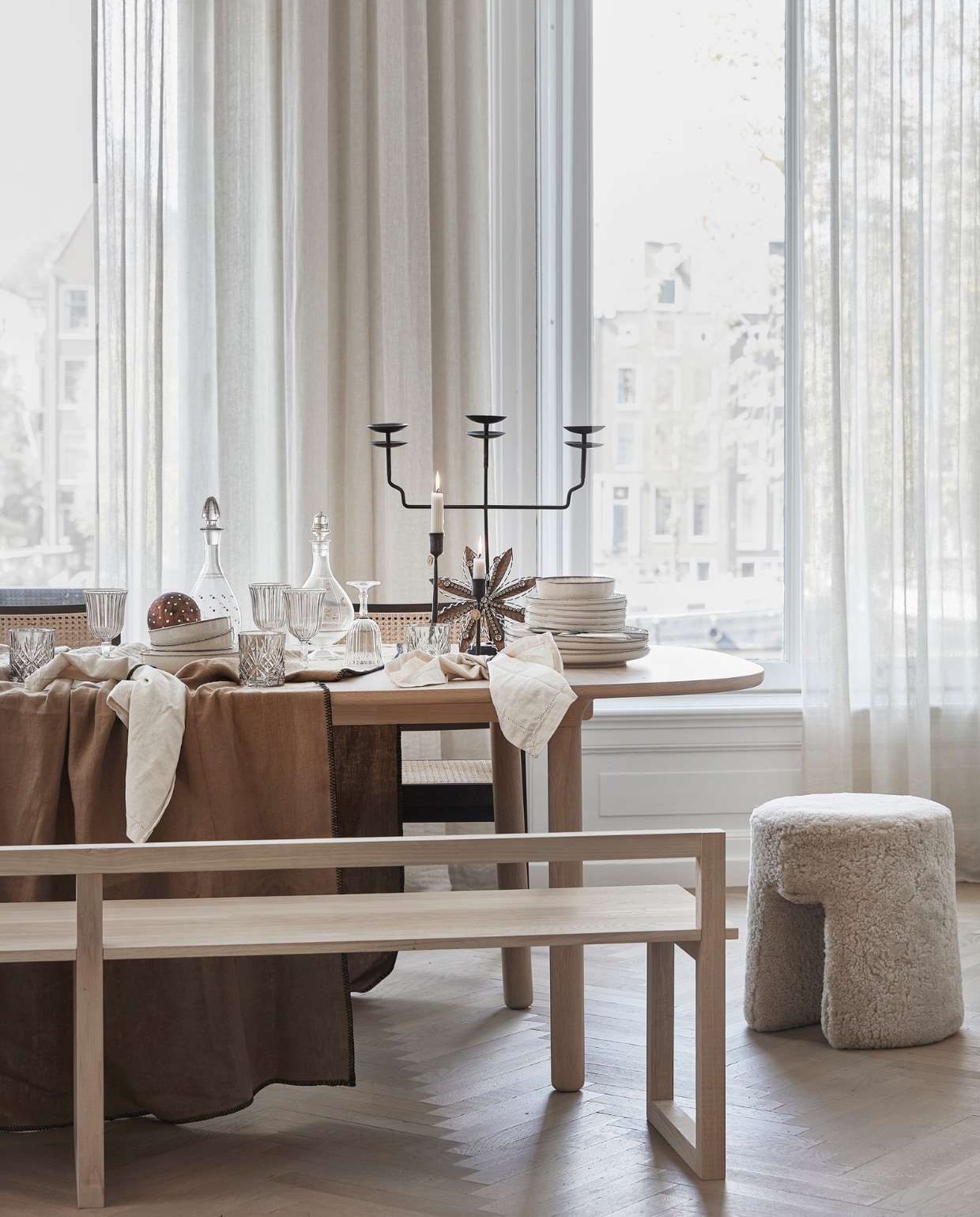 Lamswollen poef Sequioa van Frederica, 40 cm (Ø) € 1269,- (designtales.nl). Donkerbruine rotan eetkamerstoelen Pierre met armleuning, per stuk € 399,- (aimetestudio.com). Linnen tafelkleed Lola kleur Tabac, 170x300 cm € 132,95 (casagitane.com). Wijnglazen, per stuk € 3,99, drinkglazen, per stuk € 7,99, beige servies vanaf € 6,99, servetten, per 2 € 9,99 (zarahome.com). Dinerkaarsen ribbel, per stuk € 2,35 (bluryourlife.com). Zwarte lantaarn van Taiwan Lantern € 1150,- (entertheloft.com). Zwarte, drie-armige kandelaar € 57,95, zwarte kandelaar M € 18,25 L € 19,25, sneeuwvlokhanger € 15,50, handgemaakte koperkleurige kerstbol met stippen € 6,95 (weldaad.com). Witte papier-maché schaal Earth van Serax € 179,-, zwarte messing servetringen van Ferm Living, per 5 € 32,99 (vtwonen.nl). Oude glazen karaffen (kringloopwinkel). Gordijnen privébezit. vtwonen 12-2022 | stling Kim van Rossenberg | uitvoering Richard van Meerveld | fotografie Peggy Janssen