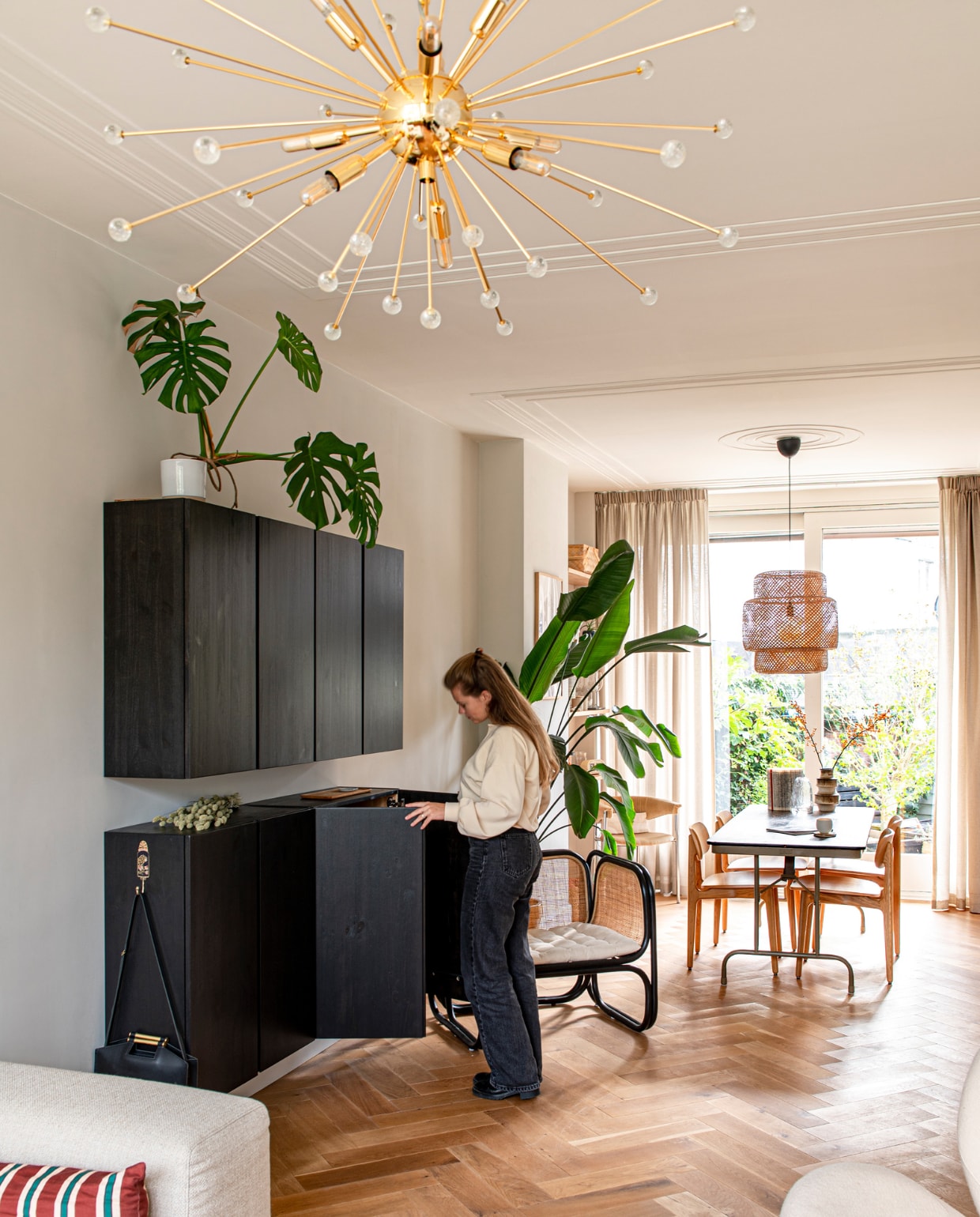 Wandkasten Ivar en rieten hanglamp Sinnerlig van Ikea. Haak Doing Goods, oude legertafel Marktplaats, stoelen PLC van Modus Furniture, fauteuil Long Beach van Loods 5, hanglamp Sputnik via Catawiki, kussen Sissy-Boy, gestoffeerde stoelen vintage. Overig onbekend.