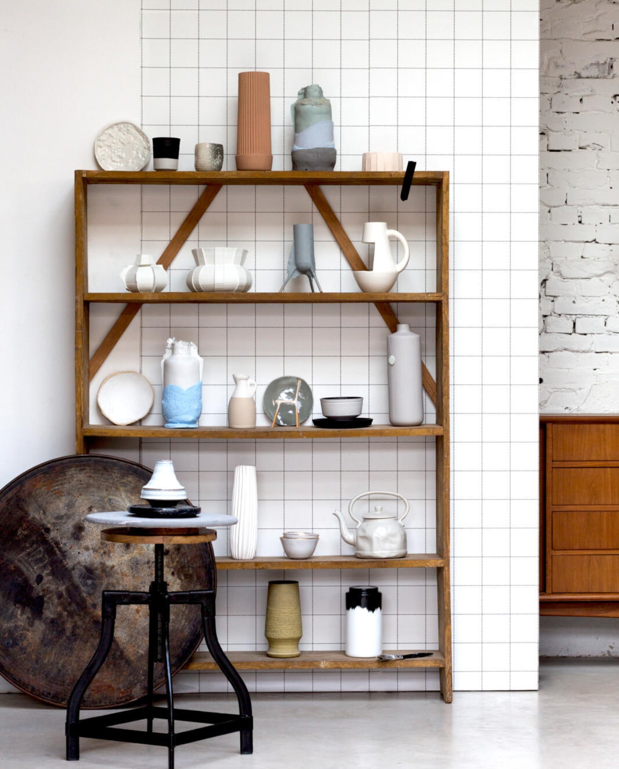 Kast 110x25x61 cm (hxdxb) € 189,- (Old Basics). Houten draaischijf en kruk, kleine zwarte schijf (privébezit). Grote houten draaischijf, grijs geschilderd Ø 39 cm € 6,99 (Ikea). Vaasje op kruk € 11,95 (Villa Jipp). Bovenste plank v.l.n.r.: bord € 60,- (Daniel van Dijck), grijs/zwarte mok, € 26,- (Mae Engelgeer i.s.m. Cor Unum), kleine mok (privébezit), hoge bruine vaas € 50,- (Restored), grijze vaas € 350,- (Studio Jeroen Wand), lage vaas € 22,50 (Lukilli). Tweede plank van boven: kleine witte vaas € 35,- (Store without a home), grote witte vaas € 100,- (Dik Scheepers), grijze vaas op pootjes, proefmodel (Studio Jeroen Wand), vaas met open stuk € 36,50 (Pols Potten).Derde plank: bord € 20,63 (Lukilli), blauw/witte vaas € 350,- (Studio Jeroen Wand), karaf € 82,- (Vormvrij). Groen bord € 23,50 (&amp;klevering), zwart bord € 28,- en schotel € 26,- (Mae Engelgeer i.s.m. Cor Unum), hoge vaas € 69,- (Restored).Vierde plank: witte vaas € 60,- (Dik Scheepers). Kom € 20,50 en grote kom € 32,50 (Anouk Kramer), theepot € 39,95 (Store without a home). Onderste plank: geelbruine vaas (privébezit). Vaas dip € 54,- (&amp;klevering). vtwonen 03-2016 | styling Anke Helmich | fotografie Sanne Tulp