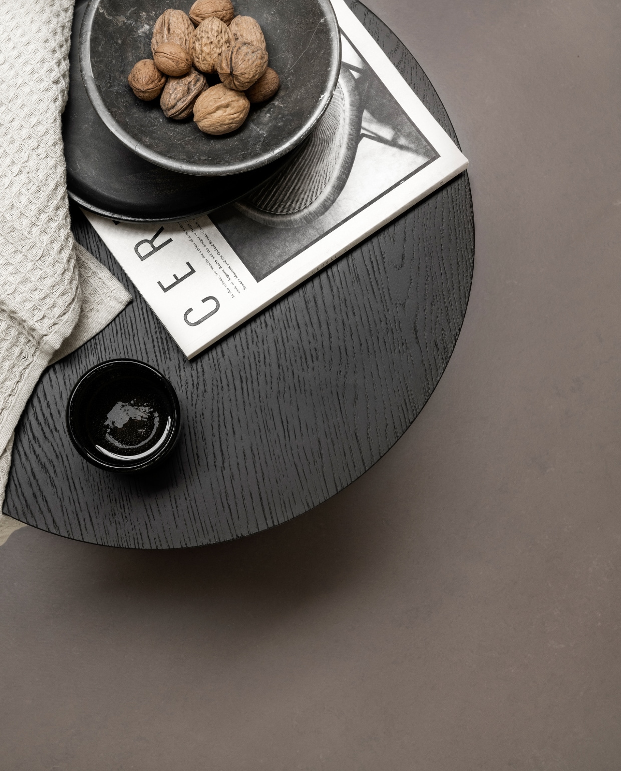 Marmoleum vloer in Klei, 200 cm breed, per m² € 50,40.M.m.v. ethnicraft.com (bijzettafel), zarahome.com (zwart houten bord), hm.com (stenen etagère, handdoek). Overig privébezit. vtwonen 10-2023 | styling Sanne Ketelaar | fotografie Stan Koolen