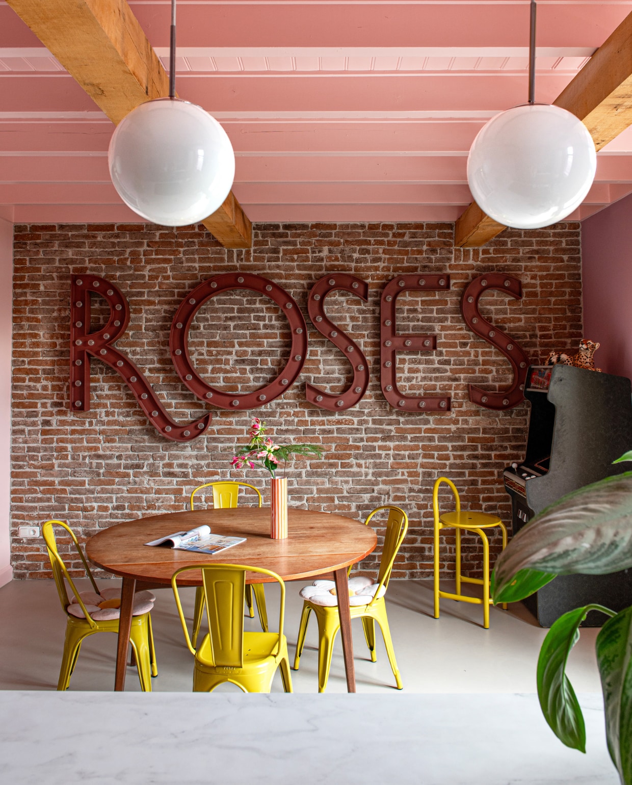 Panter vintage, stoelen Tolix, eettafel Louis van Teeffelen, lampen kringloopwinkel in Denemarken. Gamemachine en muurletters Spektakel Wonen. Vloer van BaseBeton van Poorte Vloer &amp; Wand Design. Wand- en plafondkleuren Zalm en Potpourri van Gamma. vtwonen 11-2023 | productie De Binnenkijkers | styling Jeske Weel | fotografie Caroline Coehorst