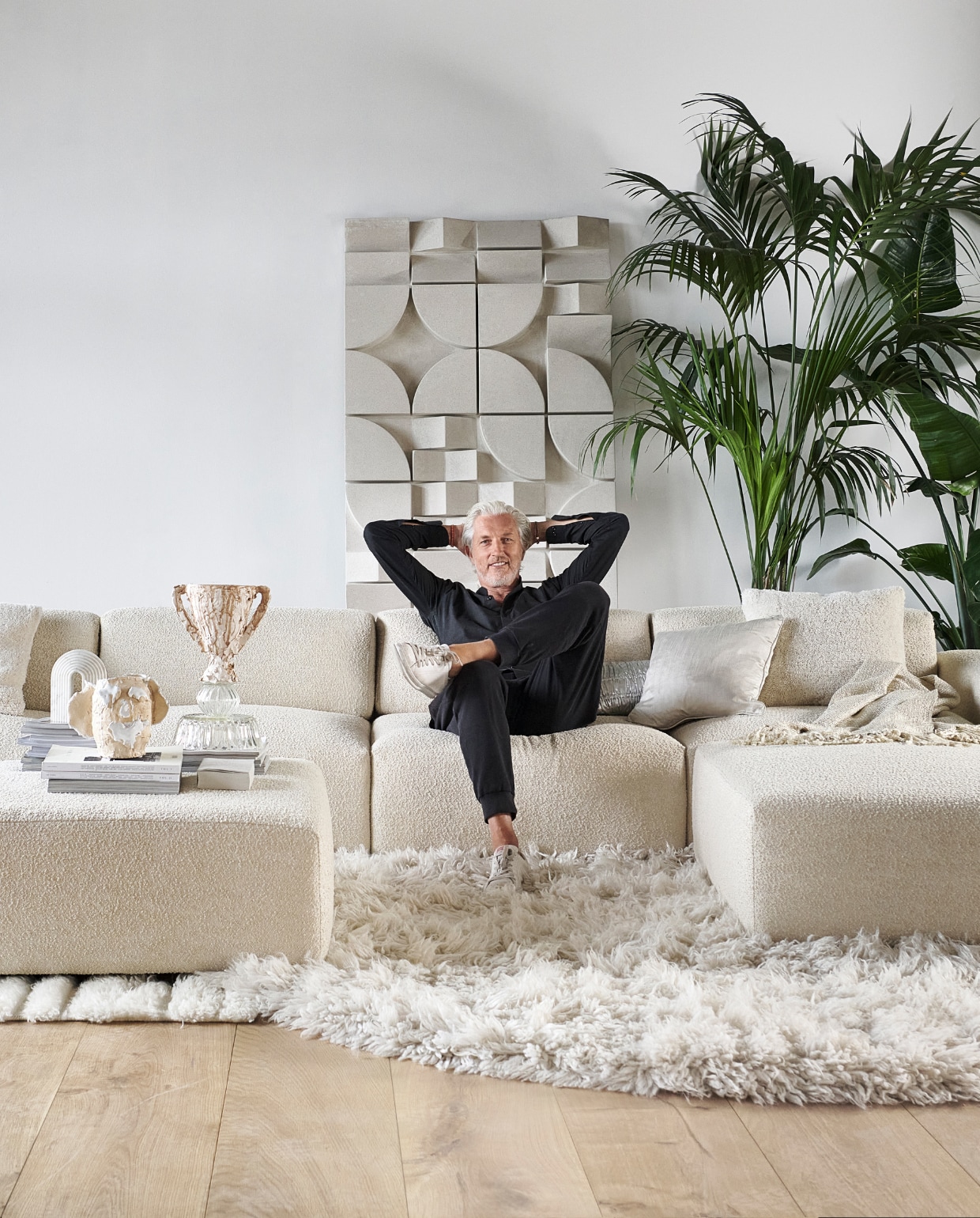 Elementenbank Cubi Spacious en poef Large van Basta in Linen Melé (basta.co). Houten parket XL in geolied eiken white wash van vtwonen, per m2 € 94,95, muurverf krijtlook Snow White van vtwonen, per 2,5 liter € 46,99 (karwei.nl). Hoogpolig vloerkleed Fluffy, wol en katoen, 250 cm (Ø) € 1575,- (hkliving.nl). Wollen vloerkleed van Brinker Carpets, hoog- en laagpolig, 200x290 cm € 1250,- (eijerkamp.nl). Wandpaneel Montañas, 175x100 cm € 1249,- (lanena-home.com). Polyester bijzettafel Zig Zag van Polspotten € 345,-, hanglamp Nelson Saucer Bubble van Hay € 695,-, acryl plaid Solid van Malagoon in Ivory € 49,95, aardewerken vaas Moire van Ferm Living € 139,- (vtwonen.nl/shop). Wollen kussen Tufted Solid € 59,95 (malagoon.com). Zilveren katoenen kussen New Age van HKliving, € 49,95, porseleinen gebouwen van Joost Gijzel, per stuk € 79,- (loods5.nl). Zijdeglanzend kussen € 50,-, aardewerken plantenpot € 225,- (nordal.com). Marmeren boekensteun Ferro van Nordal € 68,- (deens.nl). Tweedehands wandtafel € 100,- (delokatie.nl), geverfd in hoogglans lak White Wood nr. 201 van Lab Paint, 500 ml € 47,- (vestingh.nl). Kunstobjecten, aardewerk en gerecyclede materialen, vanaf € 150,- (vazenvanjanssen.nl). Gipsen cirkel €85,-, venusbeeld € 59,90 (het-schippertje.nl). Overig privébezit. vtwonen 2023-11 | styling Marianne Luning | fotografie Sjoerd Eickmans