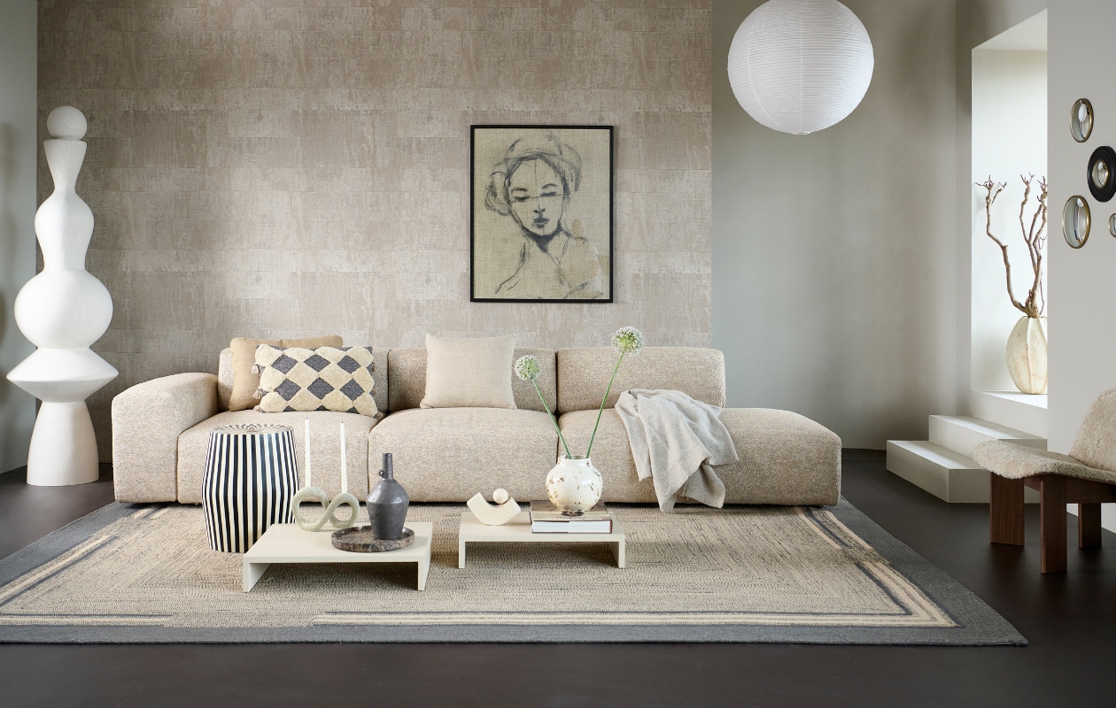 Elementenbank Cubi Sectional Open End van Basta in Warm Grey Melé (basta.co). Muurverf krijtlook Flax van vtwonen, 1 liter € 20,99 (karwei.nl). Vinylbehang Atelier d'Artiste VP88077 van Élitis, 10x1 m (lxb), per rol € 225,-, sisal vloerkleed Disco van Élitis, gerecyclede petflessen, 250x350 cm € 2500,- (loggerewilpower.com). Ingelijst portret € 1500,- (gracespiegel.com). Marmoleum vloer in Klei van vtwonen, per m2 € 50,40 (vtwonen.nl/verkoopadressen). Totemobject, 200 cm (h) € 1799,- (lanena-home.com). Bijzettafel Taura, mangohout met epoxylaag € 530,30 (nordal.com). Houten bijzettafels Plateau S en M van HKliving in Sand € 179,- en € 225,-, rijstpapieren lampenkap van Hay, vanaf € 40,-, aardewerken vaas Mias van Bloomingville € 37,90, keramieken vaas Janka van Bloomingville €89,99, polyresin kandelaar Dacian van Bloomingville € 46,90, natuurstenen schaal Hammam van Aquanova € 69,99, katoenen kussen Elina van Bloomingville € 54,90, wollen kussen Double Faced van Malagoon € 49,95 (vtwonen.nl/shop). Kussen Dot in Camel, katoen en linnen € 115,-, walnoothouten loungestoel Chisel in Sheepskin € 1749,-, wollen deken Mono in Creme Melange € 115,- (hay.nl). Travertin boekensteun Equi van Caché € 297,- (loods5.nl). Plantenpot € 180,- (householdhardware.nl). Wandspiegels Convex, vanaf € 27,50 (weldaad.com). Overig privébezit. vtwonen 2023-11 | styling Marianne Luning | fotografie Sjoerd Eickmans