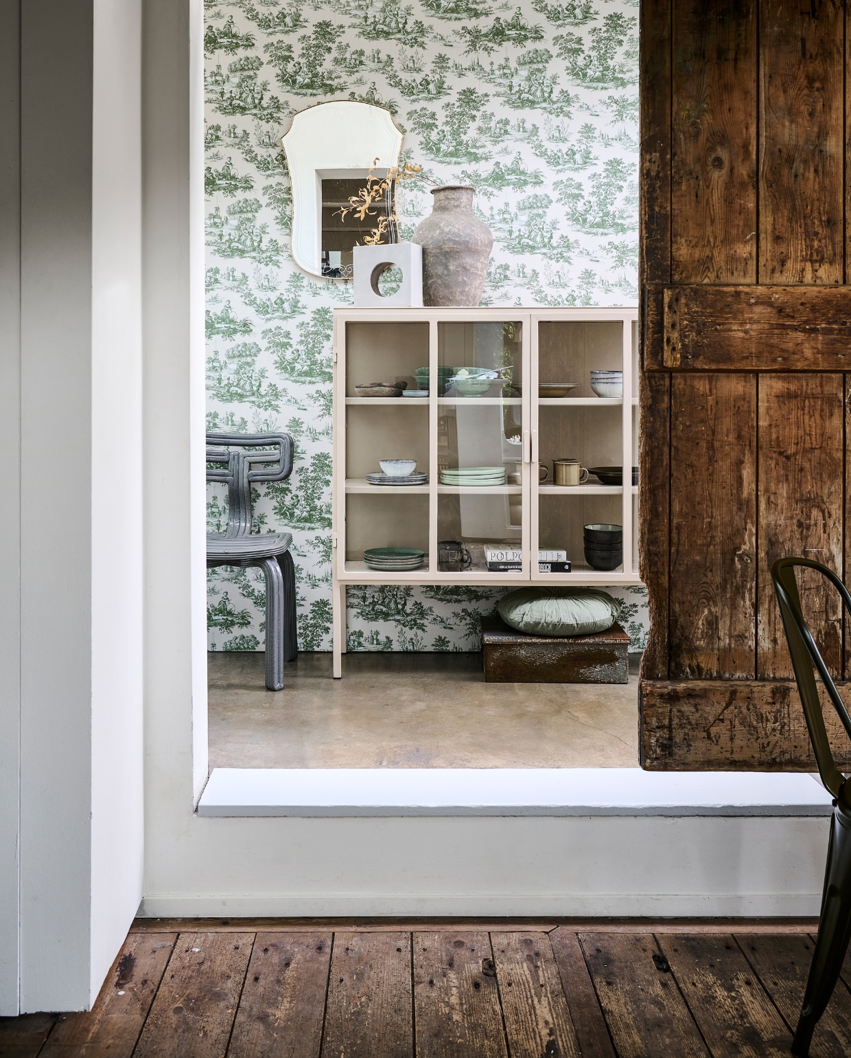 Beige metalen vitrinekast Kentucky van New Routz, 122x36x130 cm (lxbxh) € 1195,- (hetkabinet.nl). Behang Toile in 84045, per rol € 64,95 (noordwand.com). Betonnen lamp van Serax € 142,- (vtwonen.nl/shop). Papier-maché vaas € 77,95, velvet kussen Halo van BePureHome € 29,95 (basiclabel.nl). Vintage spiegel € 69,- (fortuneflea.com). Oude, ijzeren kist € 69,- (hetkabinet.nl). Stoel Chubby € 1100,- (dirkvanderkooij.com). Servies in de kast: groene aardewerken kommen Pure van Serax, 12-delige set € 292,- witte aardewerken kommen en borden met schulprand Inku van Serax, 9-delige set € 212,-, mintgroene aardewerken borden Pure van Serax, 12-delige set € 216,- metalen bekers en borden uit picknickset Yard Picnic van Ferm Living in Cashmere en Olive € 79,-, zwarte kommen Pure van Serax, 12-delige set € 266,- (vtwonen.nl/shop). Overig privébezit. vtwonen 11-2023 | styling Marlies Does | fotografie Sjoerd Eickmans
