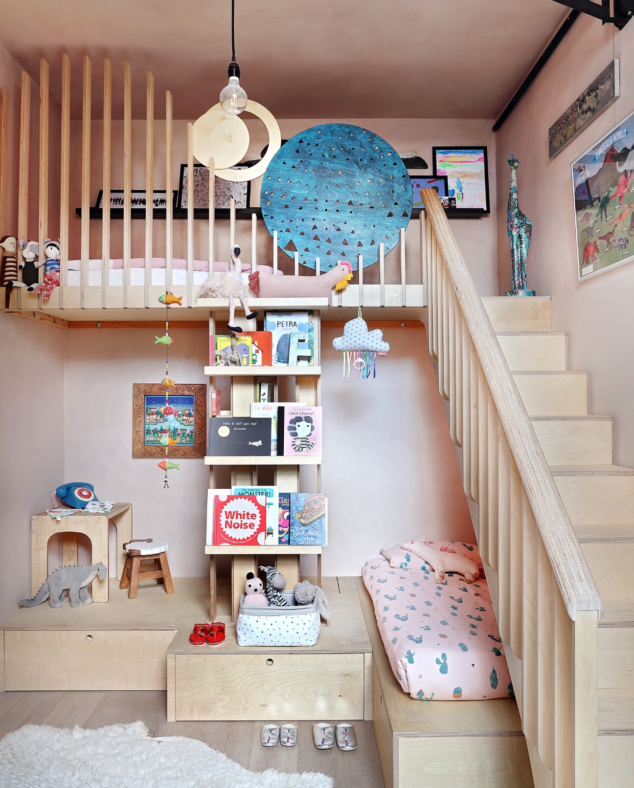 Voor de slaapkamer van de meisjes maakte Liam Dryden van Rise een slaapmeubel op maat, inclusief trap, boekenplanken, twee slaapplekken en een podium dat speelgoedlades herbergt. Rechts boven poster Dinosaur World van Marcus Walters voor Natural History Museum. Mallika en Freya hebben met de decoupage-techniek het girafbeeld gedecoreerd. Tafeltje en kruk Little Helper. vtwonen special binnenkijken 03-2020 | productie Bureaux | styling Someday Studio | fotografie Elsa Young