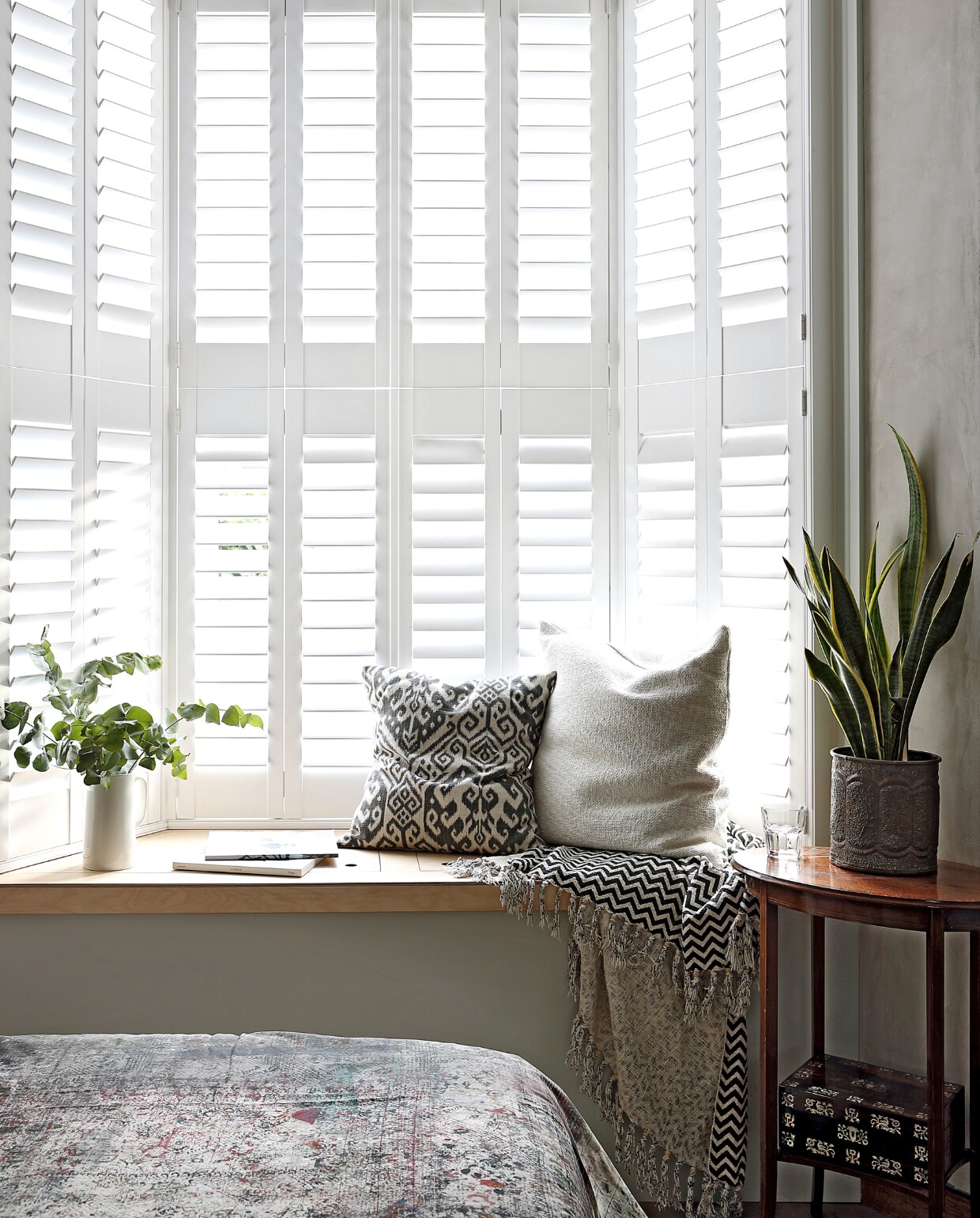 Een op maat gemaakte erkerbank met onder de klep plek voor beddengoed. Vintage wit potje van Royal Winton, zwart-witte deken uit Bali, kussens van Someday Studio. vtwonen special binnenkijken 03-2020 | productie Bureaux | styling Someday Studio | fotografie Elsa Young