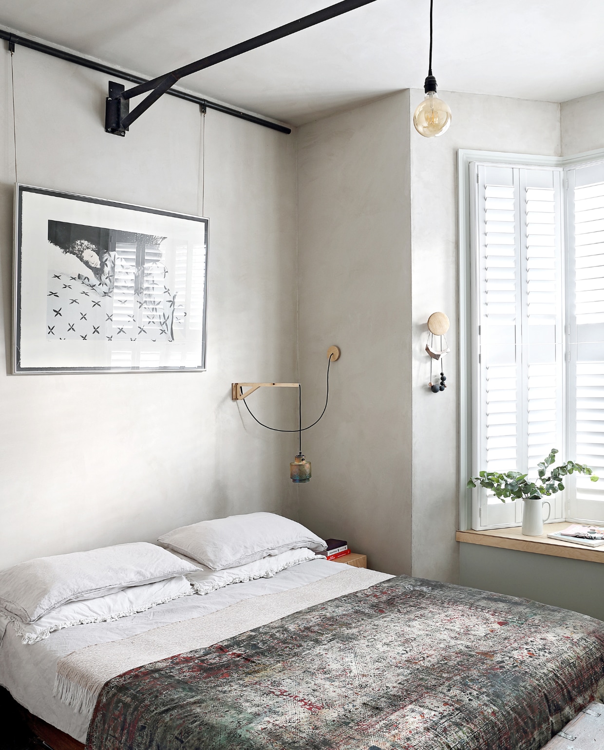 De ouderslaapkamer. Beddengoed H&M. Sprei – een doek dat bij blokdrukken wordt gebruikt om de tafel te beschermen – van een goed doel in Karachi dat Indoi steunt. Lamp Rise Design Studio, lampenkap Tom Dixon. Bij het raam Dots Coat Hooks van Muuto. Het kunstwerk kregen ze cadeau. vtwonen special binnenkijken 03-2020 | productie Bureaux | styling Someday Studio | fotografie Elsa Young