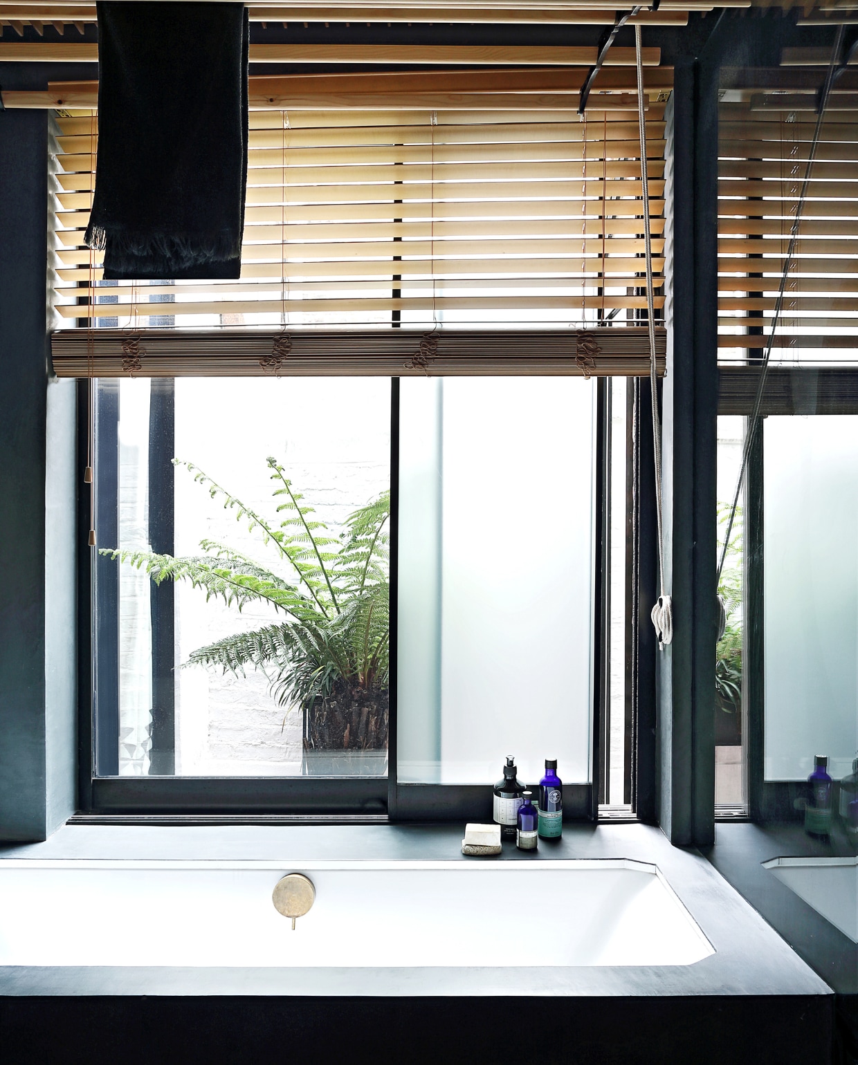 De badkamer komt uit op een kleine binnenplaats. Door de ramen stroomt zacht, gefilterd licht binnen. vtwonen special binnenkijken 03-2020 | productie Bureaux | styling Someday Studio | fotografie Elsa Young