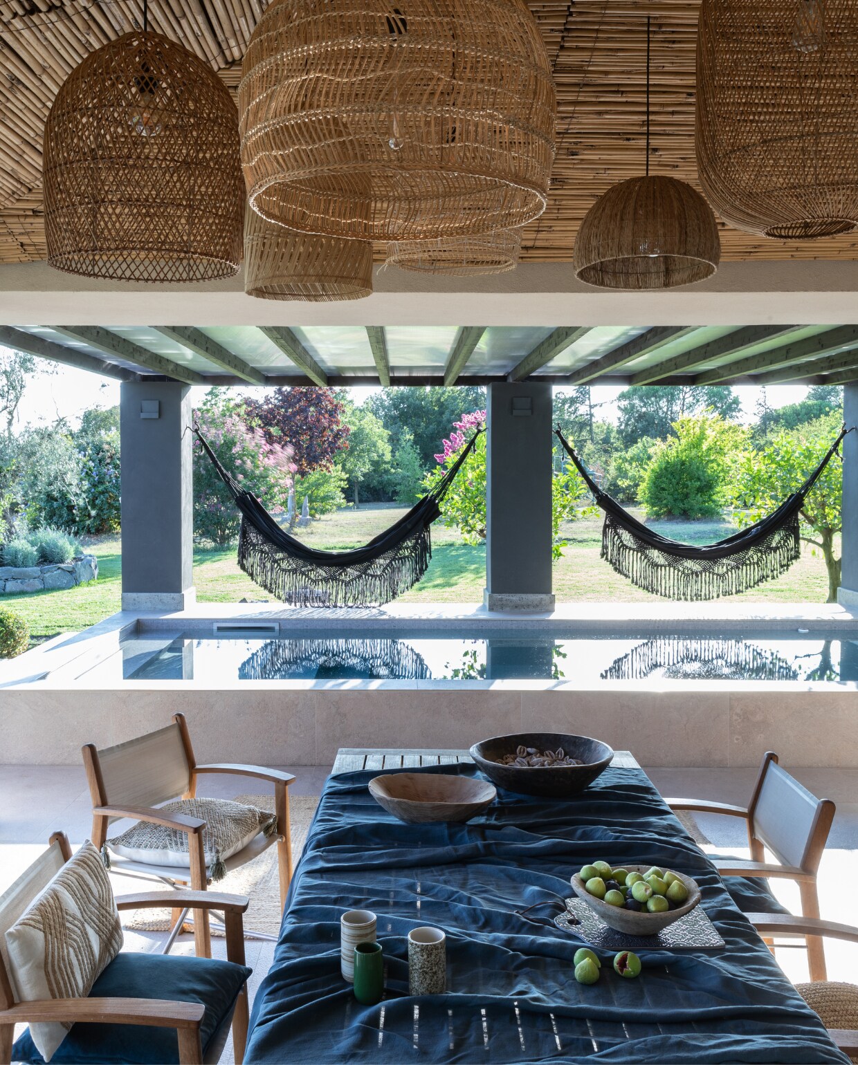 Tafel en stoelen Gloster. Bamboe lampen meegenomen van reizen. Hangmatten Todo Bien. Antieke houten schalen uit Turkije. Tafelkleed Broste. Overig onbekend. vtwonen 07-2023 | productie Living Inside | fotografie Monica Spezia