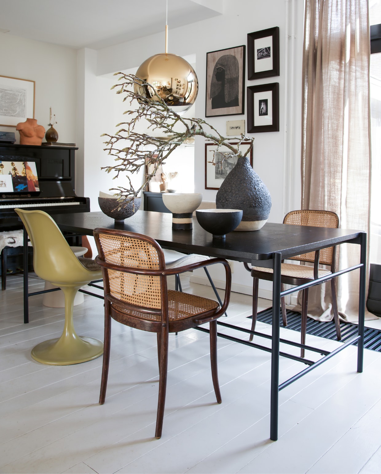 Oude Thonet-stoelen Marktplaats. Zwarte tafel Hübsch. Groene stoel met tulpvoet van Casa Gitane. Vazen en schalen handgemaakt door Liesbeth Spreeuwenberg. Designlamp Tom Dixon. Aan de wand een verzameling prints die Kris vond via Marktplaats en in de kringloopwinkel. Foto’s via de kunstuitleen in Leiden. vtwonen 09-2021 | styling José Spaans | fotografie Barbara Groen
