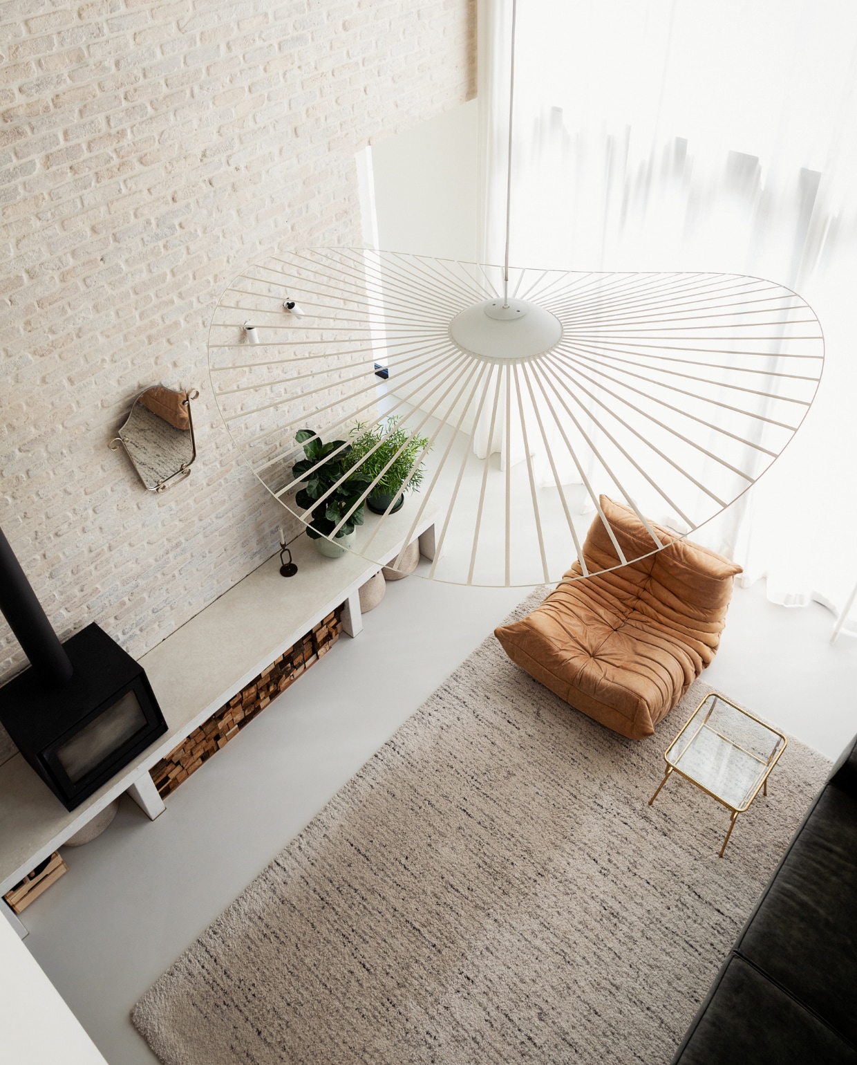 Lamp Vertigo van Petite Friture, kandelaar Zusss, kachel Barbas Bellfires, manden H&amp;M, spiegel familiestuk. Overig onbekend. vtwonen 11-2023 | styling Ilona Jongepier | fotografie Dana van Leeuwen