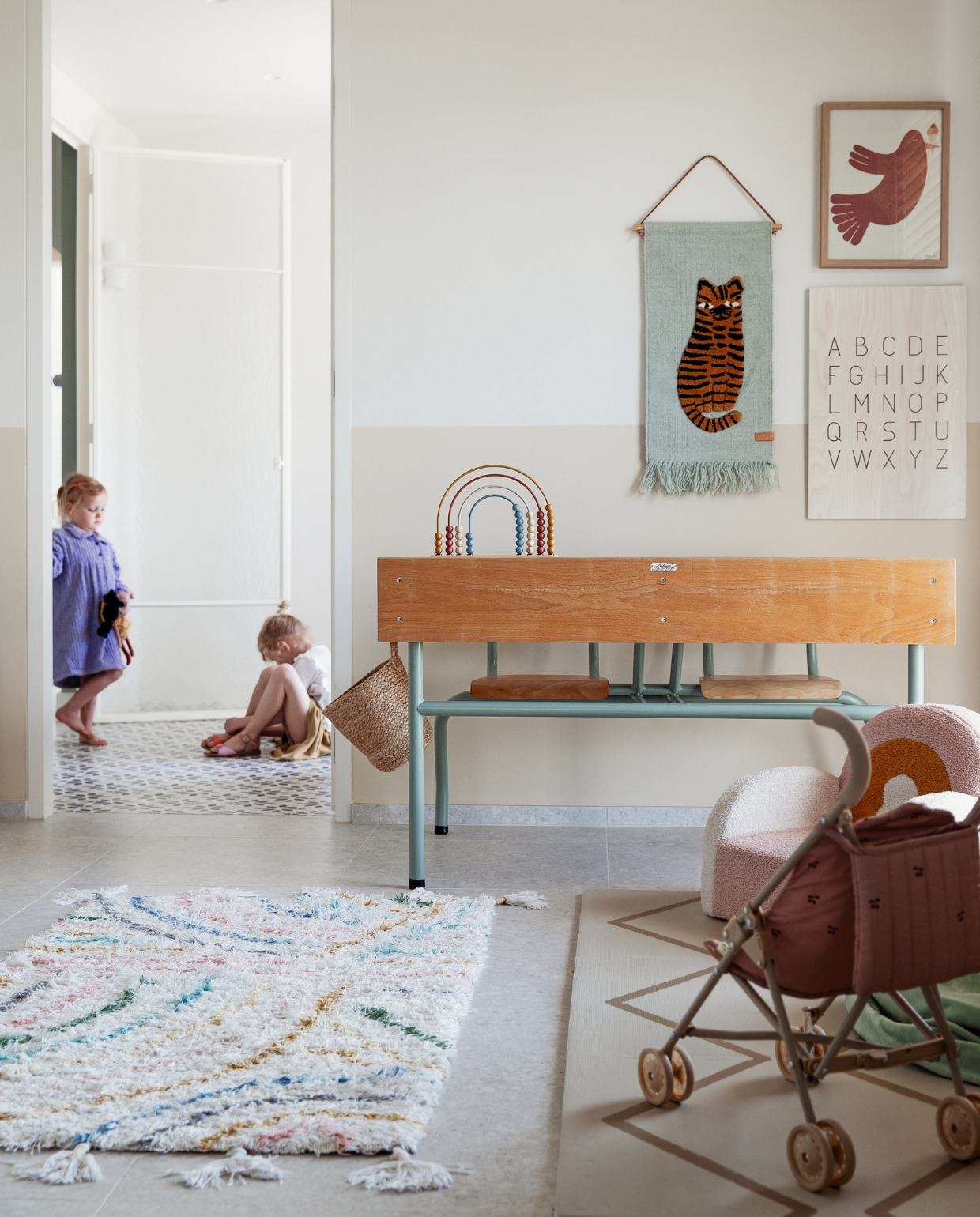 Schoolbank kringloop, vloerkleed KidsDepot, regenboogstoel Maisons du Monde, wandkleed Oyoy, letterposter Kwantum, muurkleur lambrisering Joa’s White van Farrow &amp; Ball, gietvloer kleurcode NCS S2000N van Alterieur. Overig onbekend. vtwonen 11-2023 | styling Ilona Jongepier | fotografie Dana van Leeuwen