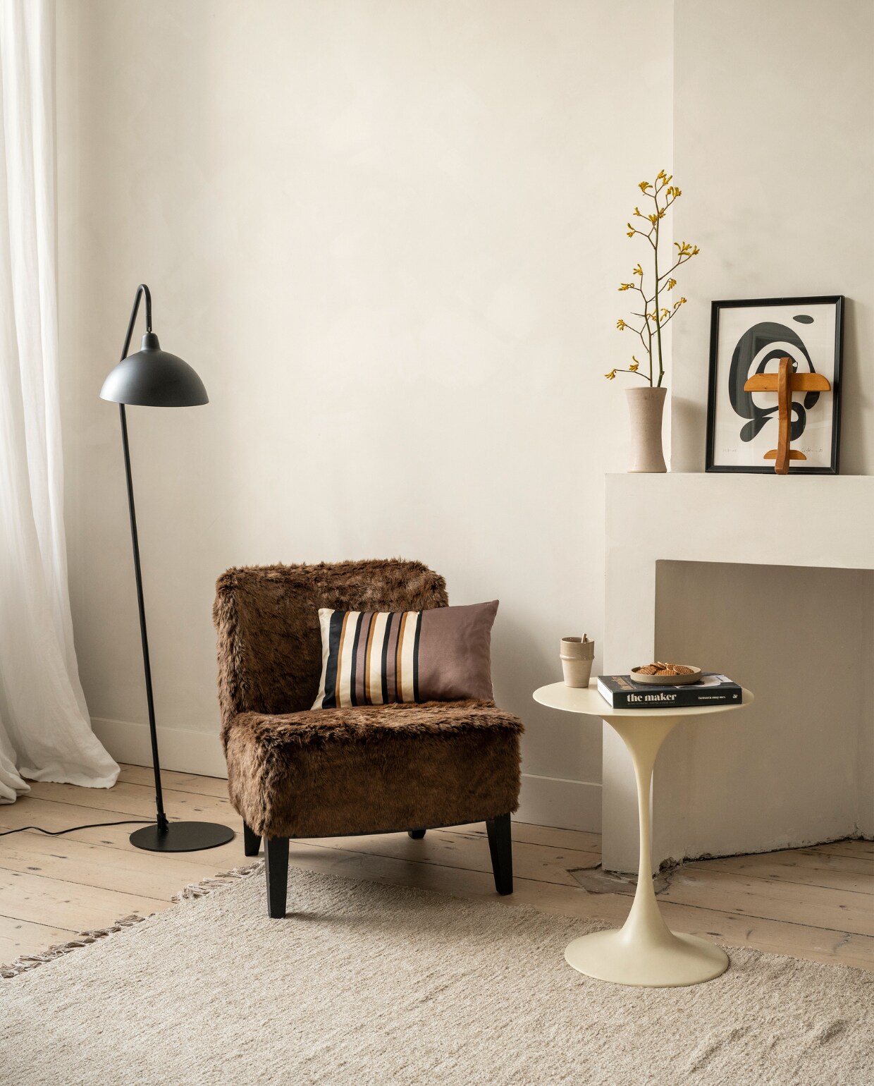 Metalen vloerlamp Orion van vtwonen € 142,95, kussen Rectangular Glossy van vtwonen € 29,95 (vtwonen.nl/shop). Meubelstof vanaf € 79,95 (stof.nl). Bijzettafel en koffiebeker, prijs op aanvraag (householdhardware.nl). Overig privébezit. vtwonen 10-2023 | styling Fietje Bruijn | fotografie Stan Koolen