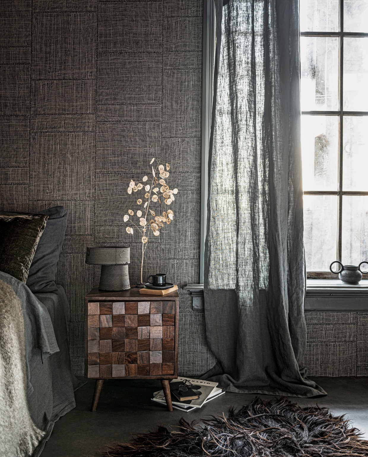 Vloer vtwonen Novilon Kwarts, 200 of 400 cm breed, per meter vanaf € 56,50 (vtwonen.nl). Behang Twine in kleur Warm Steel uit Cameo collectie, 0,70x8,5 m (bxl), per rol € 199,- (arte-international.com). Lakverf op raamkozijn Ground Pepper, per liter € 57,30 (pure-original.nl). Linnen dekbedovertrek in kleur Slate vanaf € 139,-, linnen kussensloop in kleur Slate vanaf € 28,-, mohair plaid € 199,- (bymolle.com). Grijs fluwelen kussen van William Yeoward € 96,-, gordijn gemaakt van stof Brera Lino in kleur Granite, per meter € 71,- (wva.nl). Houten nachtkastje € 149,-(zarahome.com). Keramieken tafellamp € 375,-, zwarte keramieken pot met dubbel handvat € 45,- (studio-yen.com). Zwarte kop en schotel € 9,99 (hm.com). Schapenvacht € 189,- (vachtvanvilt.nl). Overig privébezit. vtwonen 02-2021 | styling Danielle Verheul | fotografie Sjoerd Eickmans