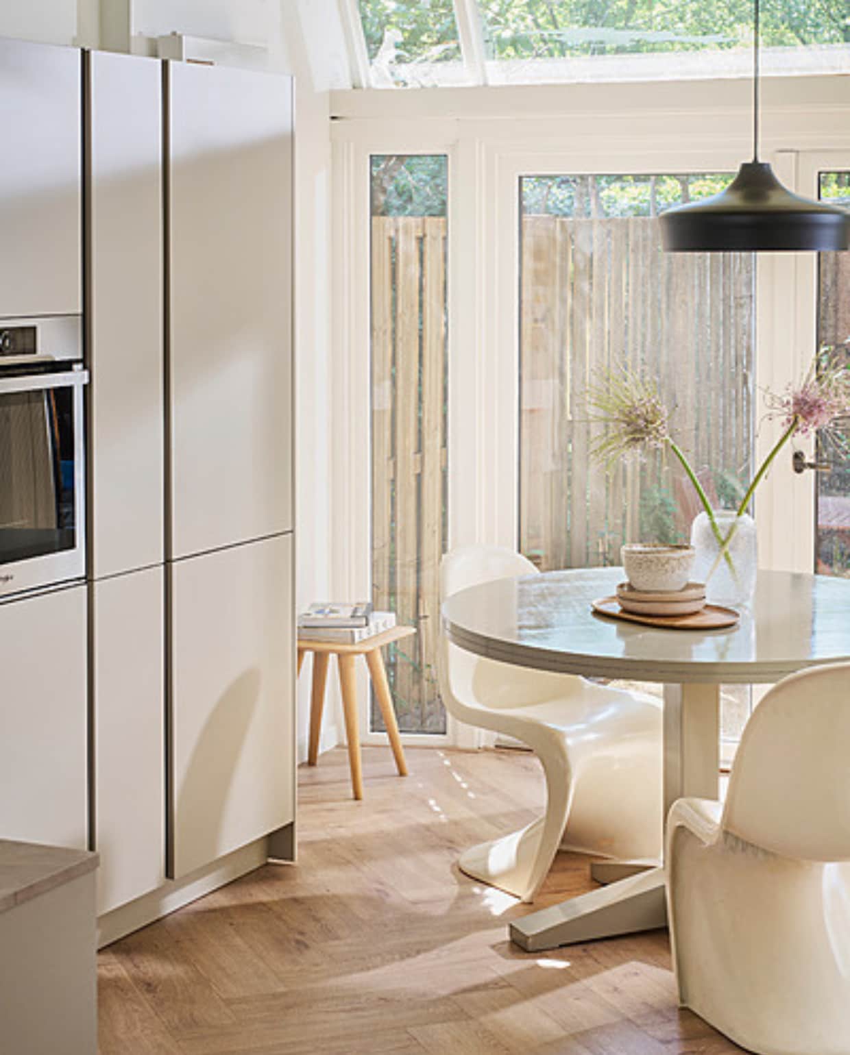 Keuken Basic Greige met diverse formaten opbergkasten, prijs op aanvraag. M.m.v. bolia.com (karaf, vaas), neeflouis.nl (stoelen), demachinekamer.nl (houten kruk), zarahome.com (houten dienblad). Overig privébezit. vtwonen catalogus 2023
