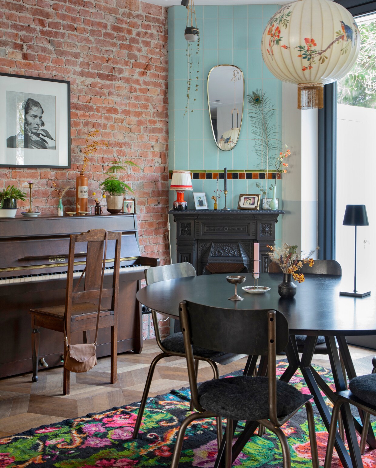 De piano was ooit van Philips oma en werd opgeknapt door Philip en Marieke. Foto erboven van fotografe Ata Kandó, gekocht bij Kahmann Gallery. Tas We Are Vintage. Spiegel boven schouw Marktplaats. Oranje lamp, vaasje en fotolijst rommelmarkt. Schouw Jan van IJken Oude Bouwmaterialen. De vintage tegels erboven komen uit een oud zwembad en werden gekocht bij Mammoet. Tafel Studio Henk. Stoelen uit een winkeltje dat niet meer bestaat. Draadloze lamp op tafel Faro Barcelona. Vaasje Loods 5. IJscoupe van een Franse rommelmarkt. Vloerkleed Rozenkelim. Spotjes Brink Licht. Lamp boven de tafel Taiwan-lantern. vtwonen 04-2020 | fotografie Margriet Hoekstra