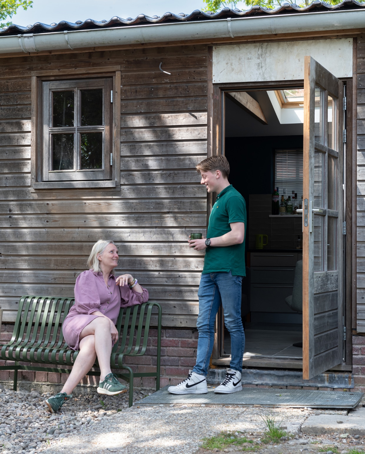 Wilma en zoon Noah bij de schuur in de tuin, waar Noah zijn privédomein heeft. vtwonen 12-2023 | styling Sharon Roest | fotografie Caroline Martinot