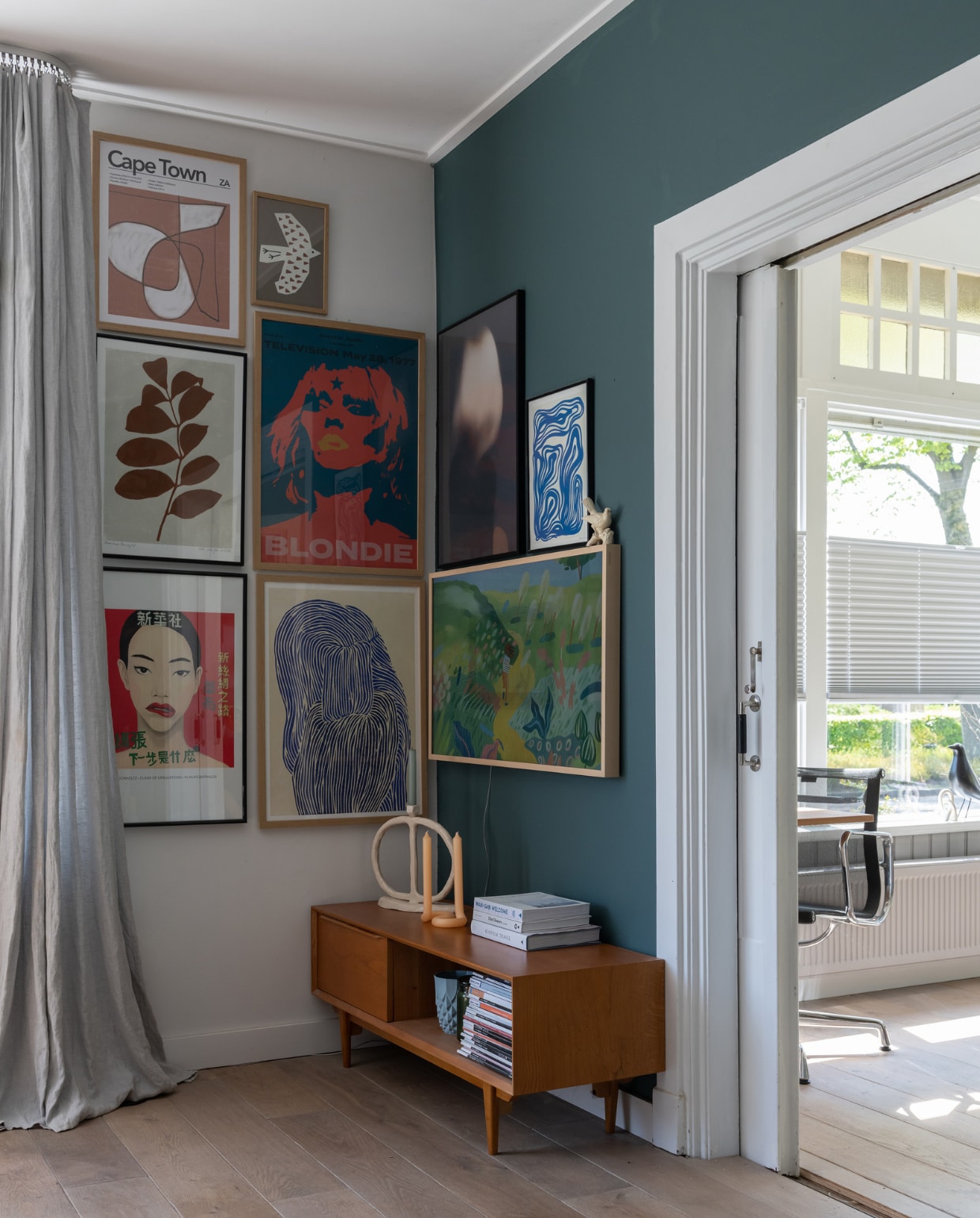 Kast Portobello van Maisons du Monde, keramieken kandelaar Junoon By Janice Jill, kaars Twist van Lex Pott, televisie The Frame van Samsung. Ingelijste posters: PrintedPlant (tak met blaadjes), AliExpress (Blondie), Plakatcentralen (vrouw linksonder), The Poster Club (blauw-crème), Gurilla (wazig portret boven tv), Yvette Heeren (kleine blauwe boven tv). Overig onbekend. vtwonen 12-2023 | styling Sharon Roest | fotografie Caroline Martinot