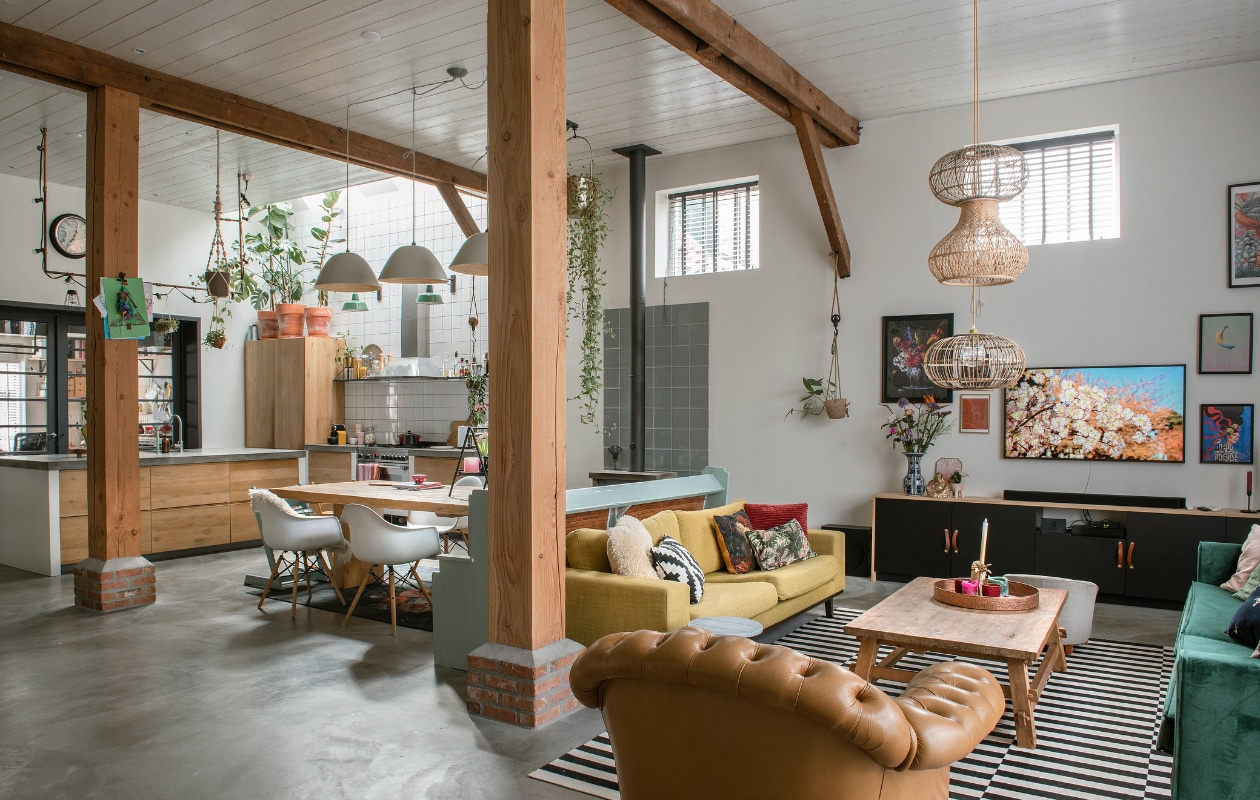 Gele bank Wehkamp, groene bank Sissy-Boy Homeland, Chesterfield stoel, koffietafel Loods 5. Vloerkleed gestreept, schapenbontje, kussen zwart-wit Ikea. Overige kussens zelfgemaakt. Rotan lampenkappen, zwart rekje, gebloemd vloerkleed Kwantum. Televisiemeubel zelfgemaakt. Dienblad Albert Heijn. Lijsten Ikea, Hema. Overig onbekend. vtwonen special DIY 6-2022 | fotografie Ton Bouwer