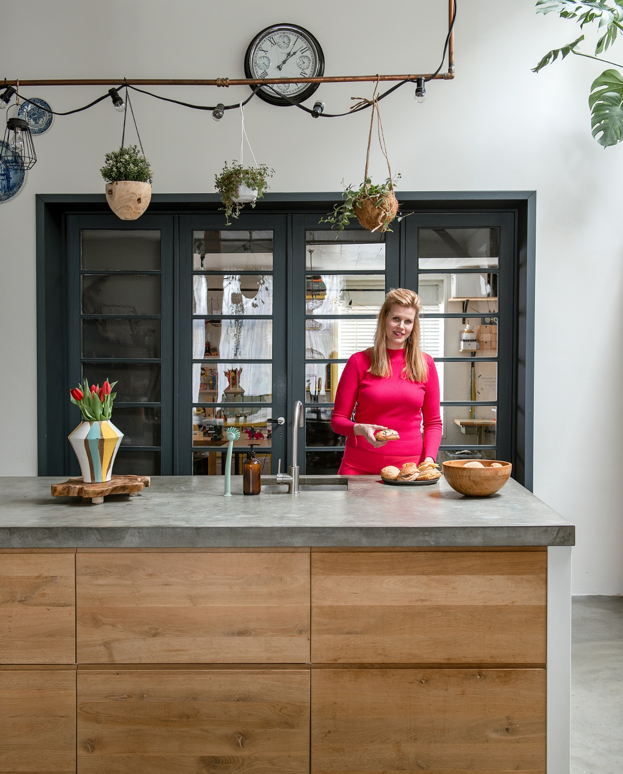 Marloes in de keuken van haar voormalige sportschool en boerderij. Keuken Koak Design met Ikea-kasten Metod, eiken fronten en betonnen blad. Koperen frame zelfgemaakt. Prikkabel en manden Kwantum. Overig onbekend. vtwonen special DIY 6-2022 | fotografie Ton Bouwer
