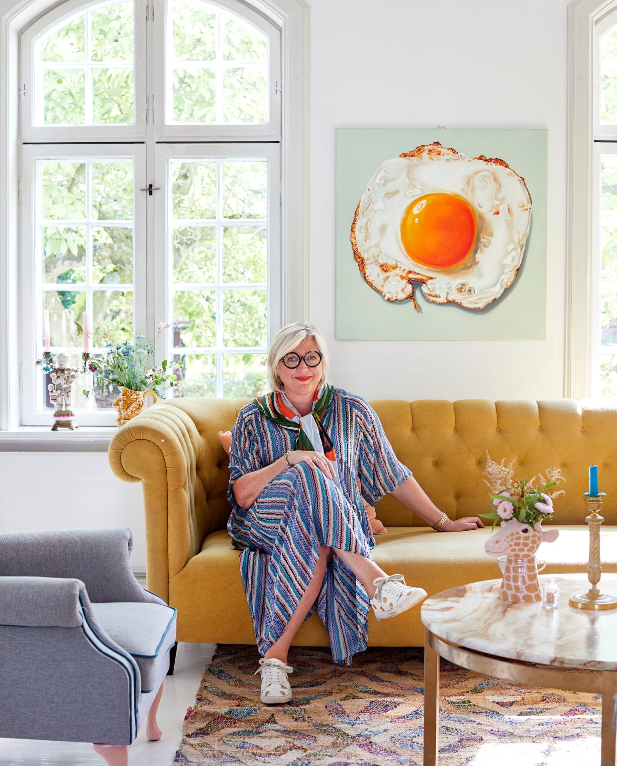 Charlotte mixt graag materialen en stijlen, ook in de woonkamer. De marmeren tafel is vintage. De meubels, het kleed en de vazen zijn van Rice. De foto van het spiegelei komt van een markt in Bangkok. vtwonen 06-2019 | fotografie Stine Christiansen