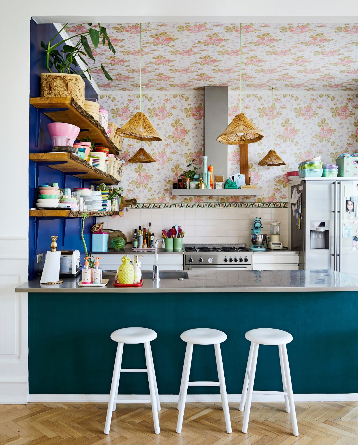 Ook in de woonkeuken zorgen wit, naturel- en houtkleuren voor balans. Bloemenbehang van Eijffinger, barkrukken van Trævarefabrikernes Udsalg. Raffia lampen, mandjes en servies van Rice. vtwonen 06-2019 | fotografie Stine Christiansen
