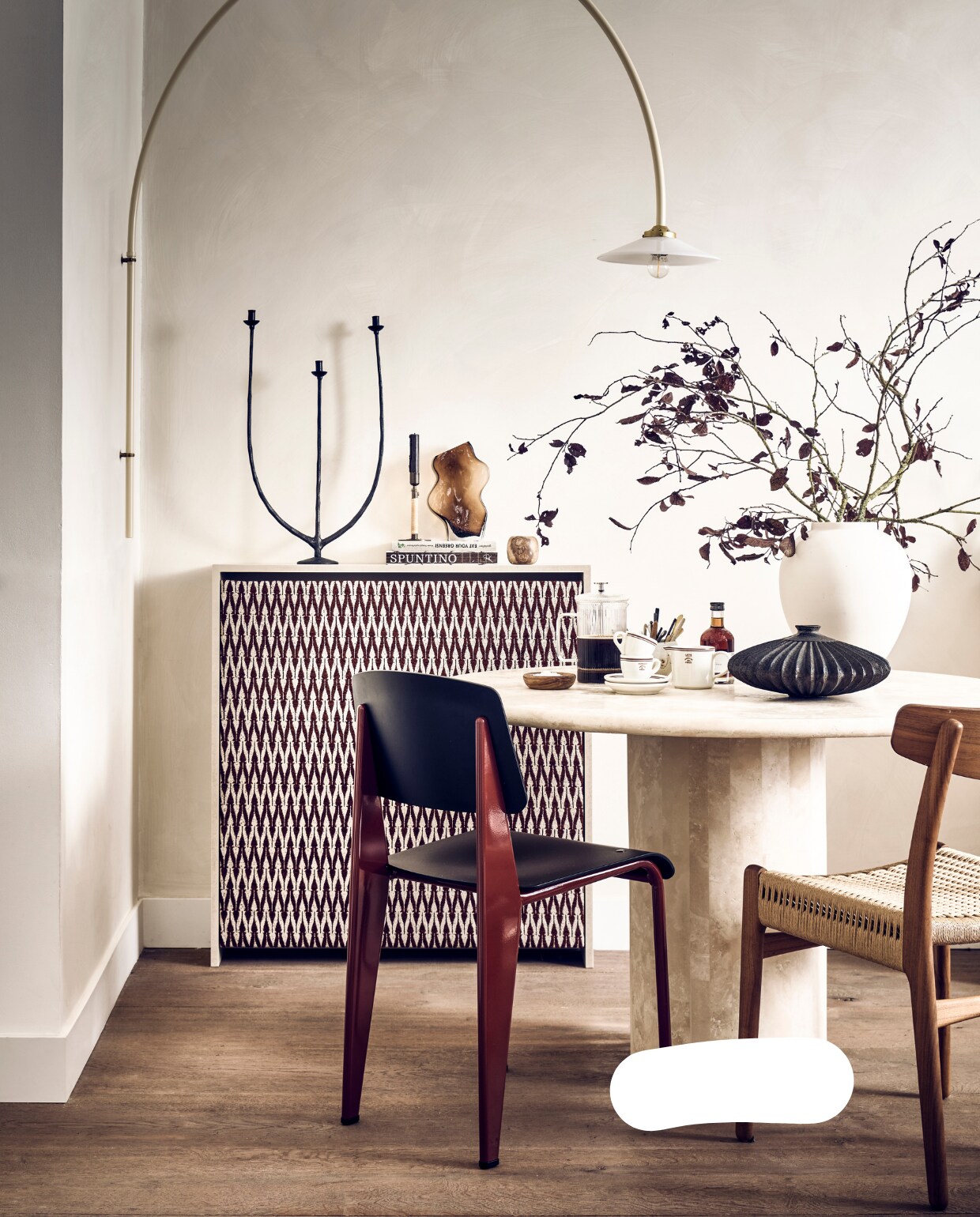 Muurverf Lime Paint in kleur Mykonos van Bauwerk (bauwerkcolour.com). Jacquard chenille-linnen stof Mio in donkerrood, 138 cm breed per meter € 59,95 (stof.nl). Wandlamp n3 Ivory € 778,- (valerie-objects.com). Rood-zwarte kunststof eetkamerstoel Standard SP van Jean Pouvré voor Vitra € 545,- (loods5.nl/design). Walnoothouten stoel met gevlochten zitting CH23 van Carl Hansen € 1356,- (misterdesign.nl). Travertin dining table Bean € 2900,- (pantoufle-design.nl). Bruine glazen vaas met golven € 24,99, flesje Syrup Caramel van Nicolas Vahé € 8,99, espressokoppen en schotels per stuk € 3,99, melkkan € 3,99 (hm.com). Bruine vaas Bo op tafel € 54,95 (casagitane.com). Kookboeken € 39,95, kandelaar met 3 armen € 39,95 (sissy-boy.com). Kandelaar Duca van Menu, bronskleurige messing met rotan, € 69,- (bymolle.com). Kleine alabaster kandelaar € 24,95 (entertheloft.com). Overig privébezit. vtwonen 11-2022 | styling Kim van Rossenberg | fotografie Sjoerd Eickmans