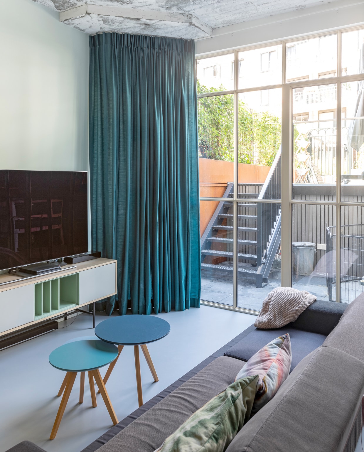 Poldersofa van Hella Jongerius van Vitra. TV-meubel Caspito van Home24. Gordijnen Combo Design (stof van De Ploeg). Verf op de wand Aquamarine Mid van Little Greene. Overig onbekend. vtwonen 03-2022 | fotografie Margriet Hoekstra